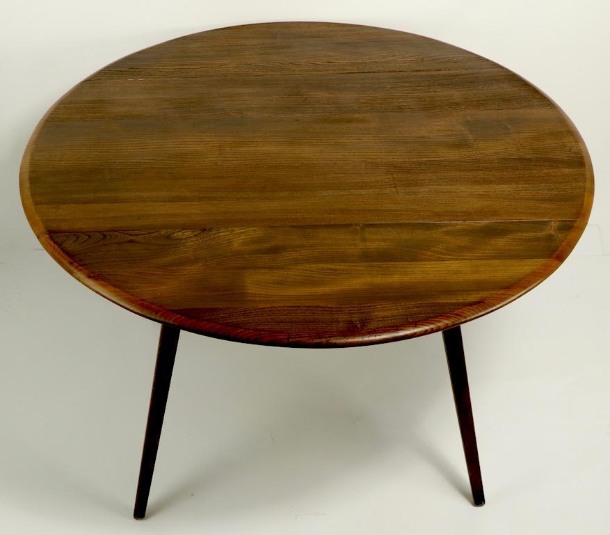 Sophisticated, architectural design drop-leaf table designed by Lucien Ercolani, for Ercol. The table feature two 12 in drop leaves, a center panel 23.5 inch W and splayed tapering legs. The table is constructed of solid ash, it is in good