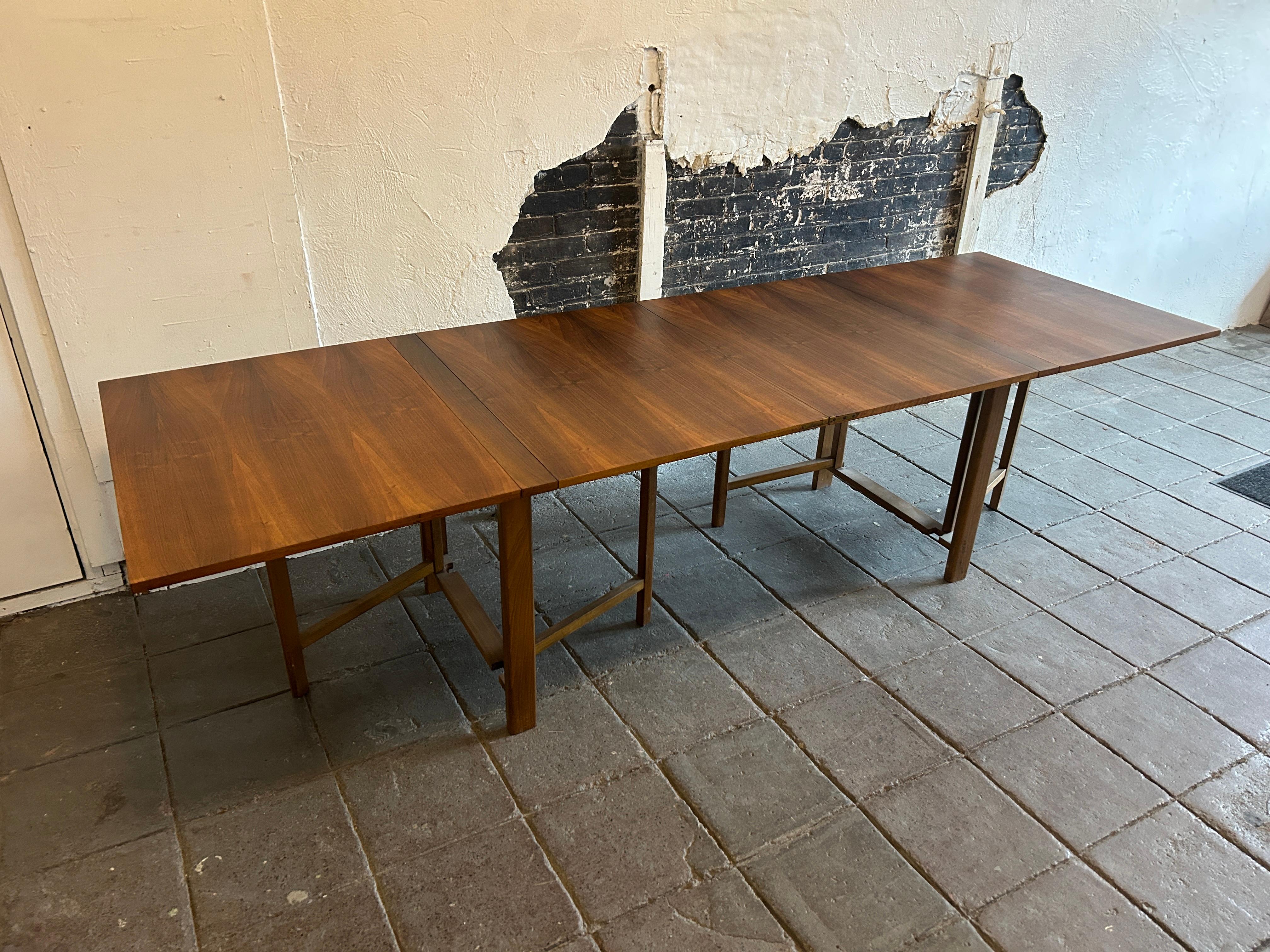 Mid-Century Modern Maria folding extension dining table by Bruno Mathsson. Table is teak wood medium brown finish with brass hardware. Good vintage condition - nice grain in veneer top. Table folds down very small to stow away while not using. Made