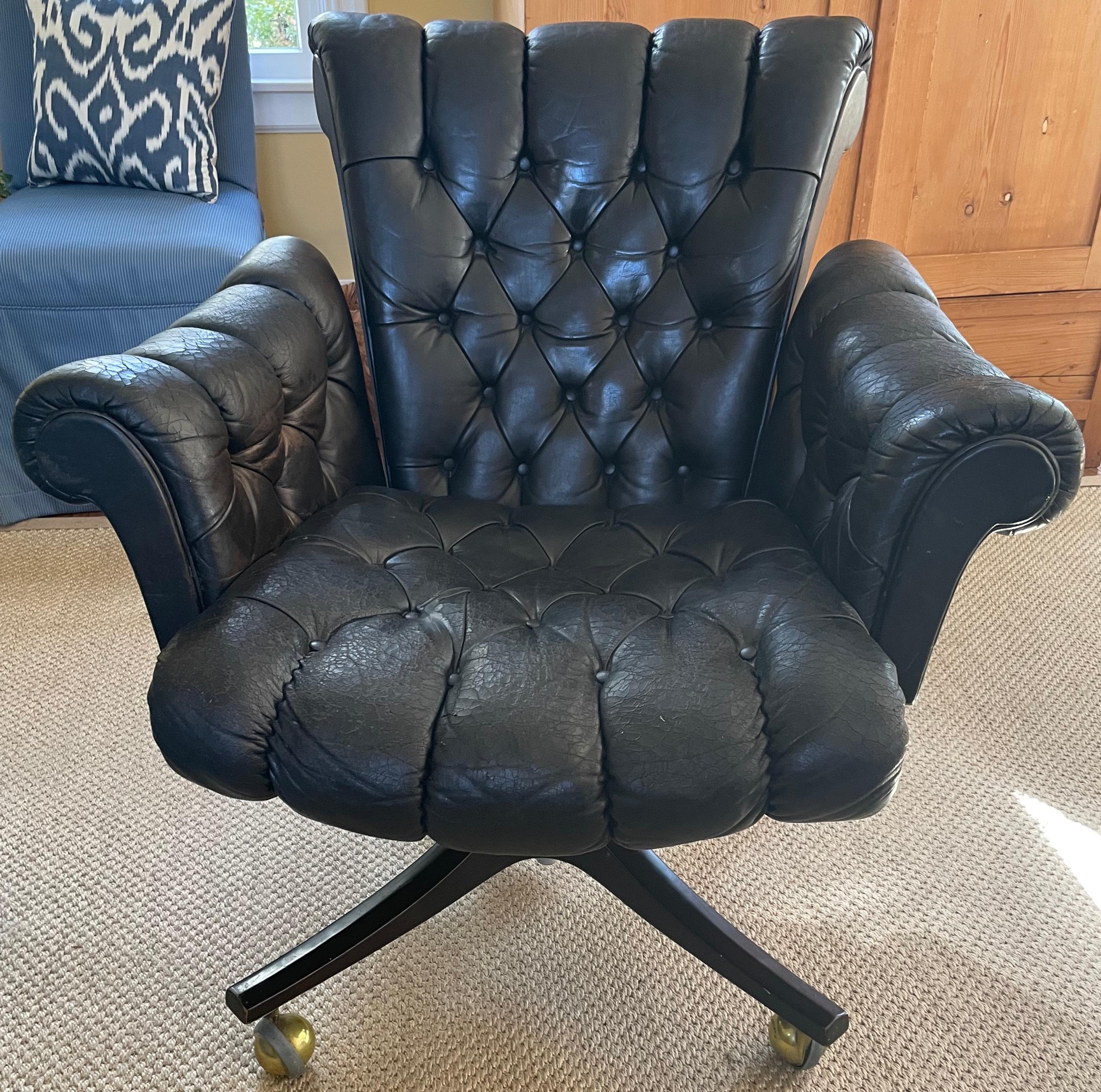 Mid-century Dunbar black tufted leather chair. Vintage tufted black leather desk/library reclining chair on patented Shepherd brass and metal casters; vintage leather with wear commensurate with age and use, no holes or punctures. United States,