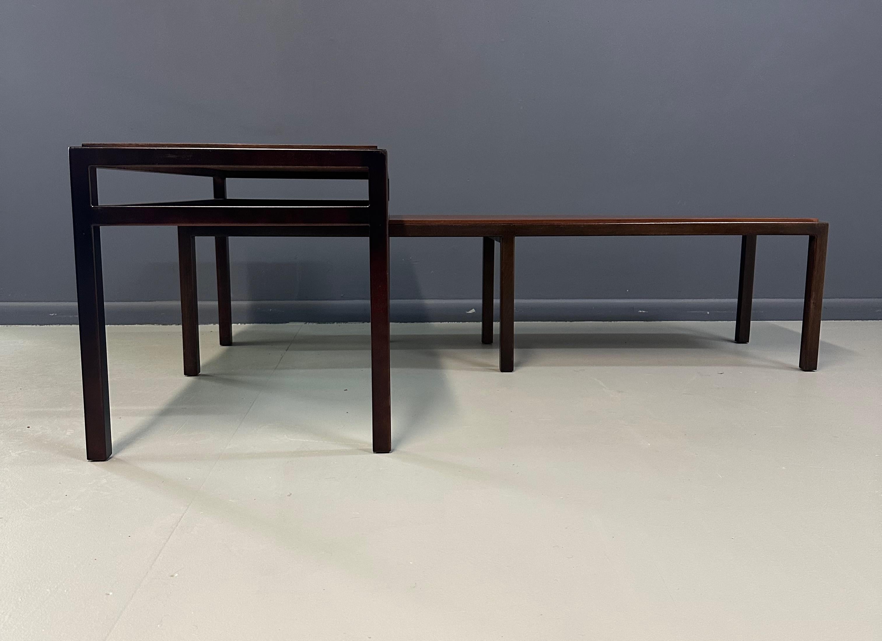 Un elegante conjunto de mesas nido modernas de mediados de siglo a la manera de Edward Wormley para Dunbar. Cada mesa presenta un tablero de nogal con expresivas vetas, enmarcado en madera ebonizada en contraste para un aspecto limpio y