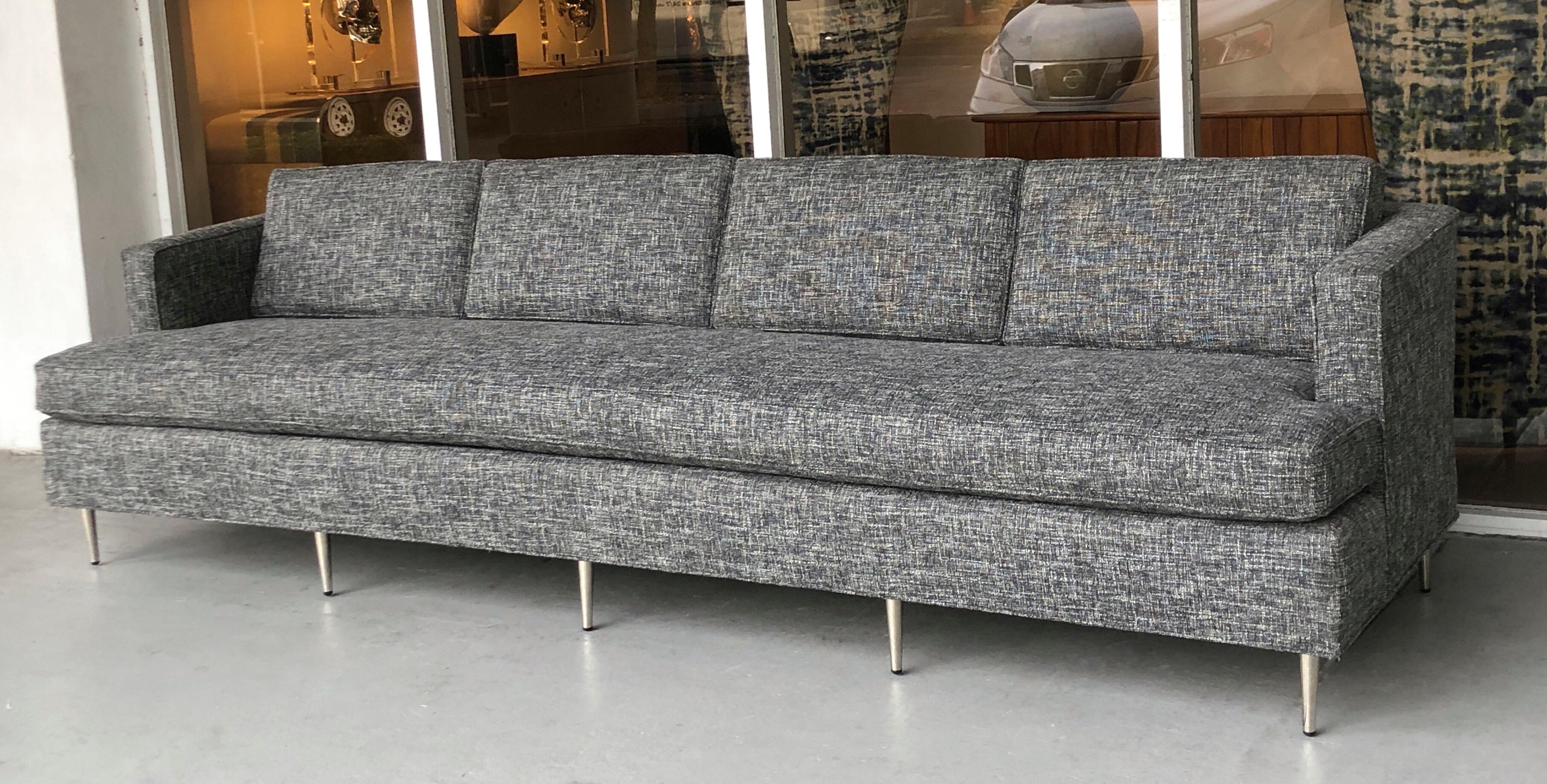 A midcentury sofa in the style of Dunbar. Newly upholstered in charcoal and white bluocle. New stainless legs.