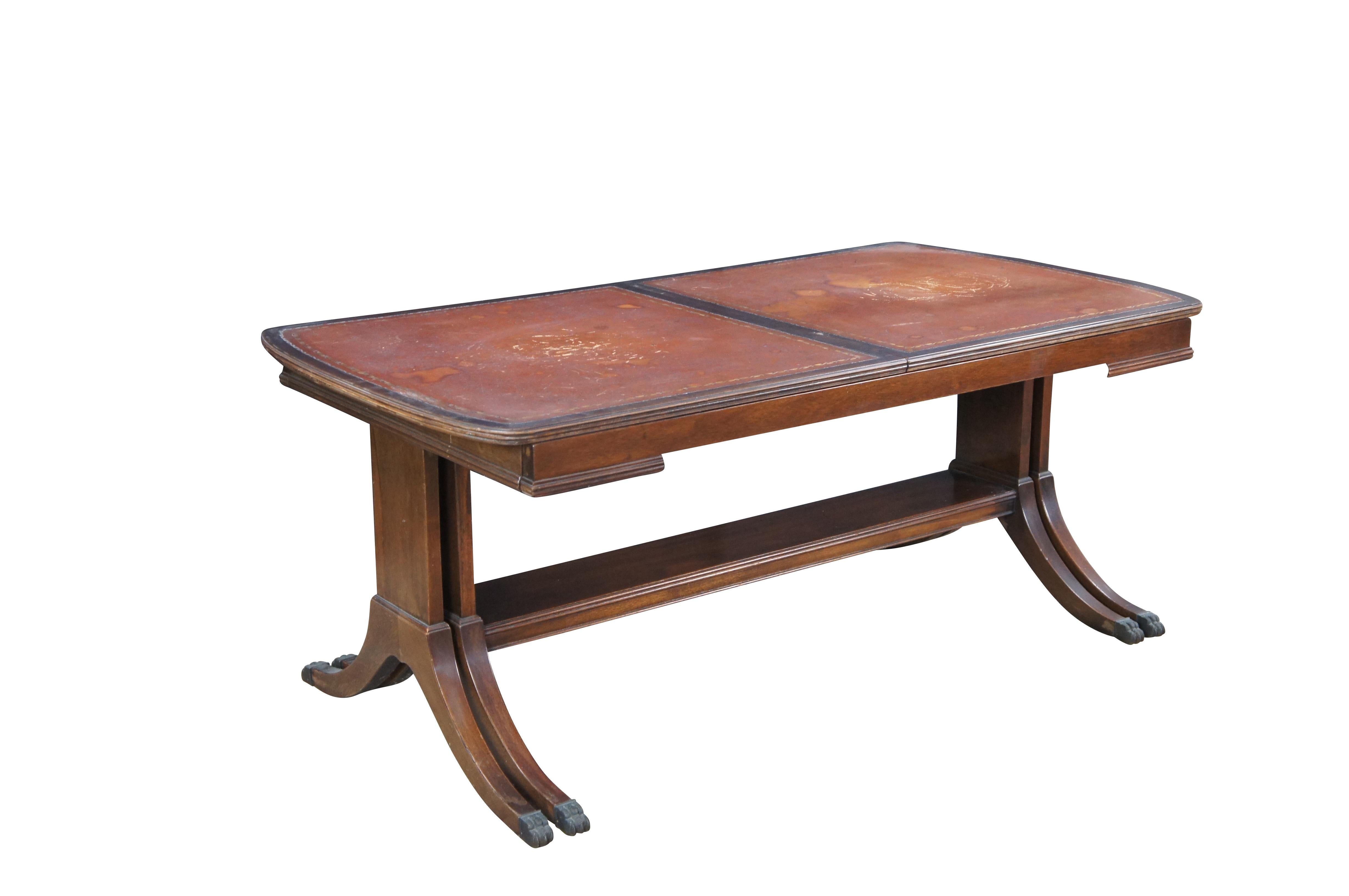 Intrigante table basse extensible de style Duncan Phyfe datant du milieu du 20e siècle.  Fabriqué en acajou avec un plateau en cuir marron estampé.  La table a une base coulissante à 8 pieds qui s'ouvre de 40