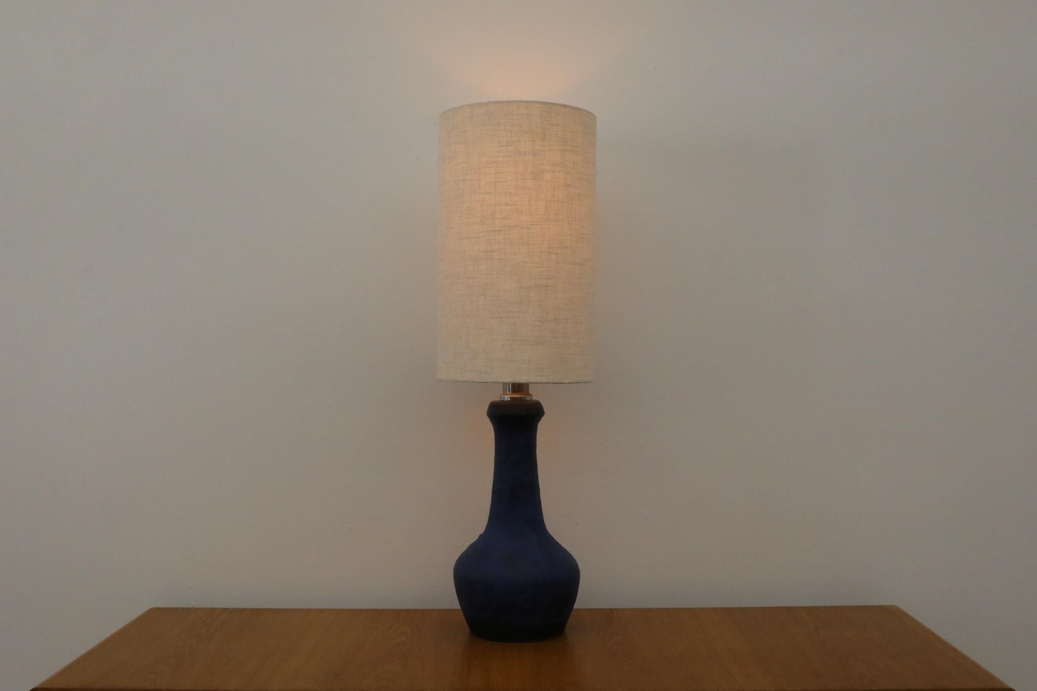 Mid-Century Dutch ceramic table lamp with stunning blue glaze and cylindrical shade. Produced in the 1950s in The Netherlands in a style not too dissimilar to the work of Swedish ceramicist Carl-Harry Stålhane. The light is in good original