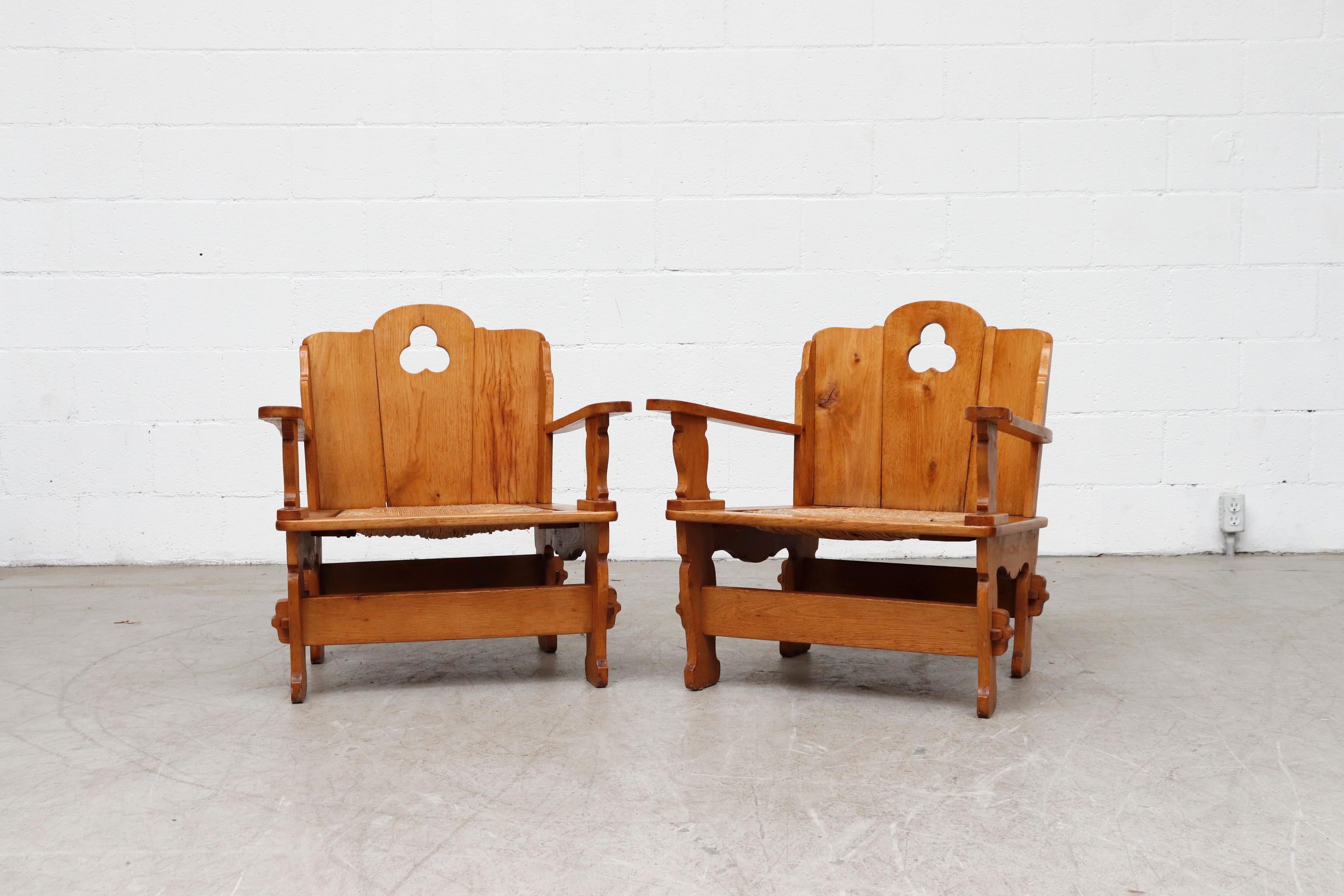 Beautiful Dutch midcentury Dutch country pine throne chairs with inset rush seat, tension peg construction and decorative cut-outs. In original condition with wear consistent with age and use. Set price.
