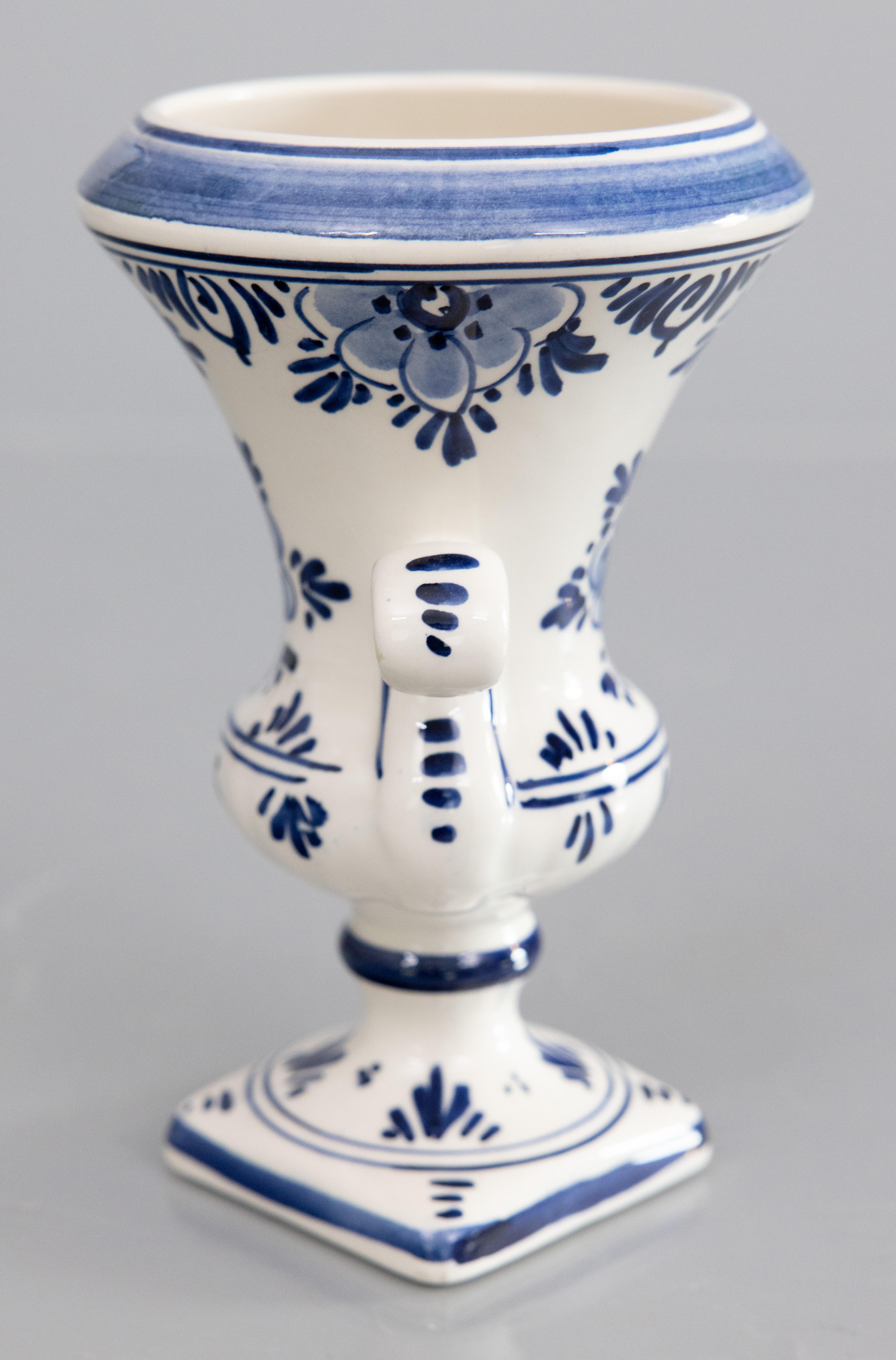 Eine bezaubernde kleine holländische Delft-Sockel-Urne oder -Vase, hergestellt in Holland. Herstellermarke auf der Rückseite. Diese feine Urne hat ein wunderschönes Blumendesign mit hübschen verzierten Griffen in den traditionellen Delfter Farben