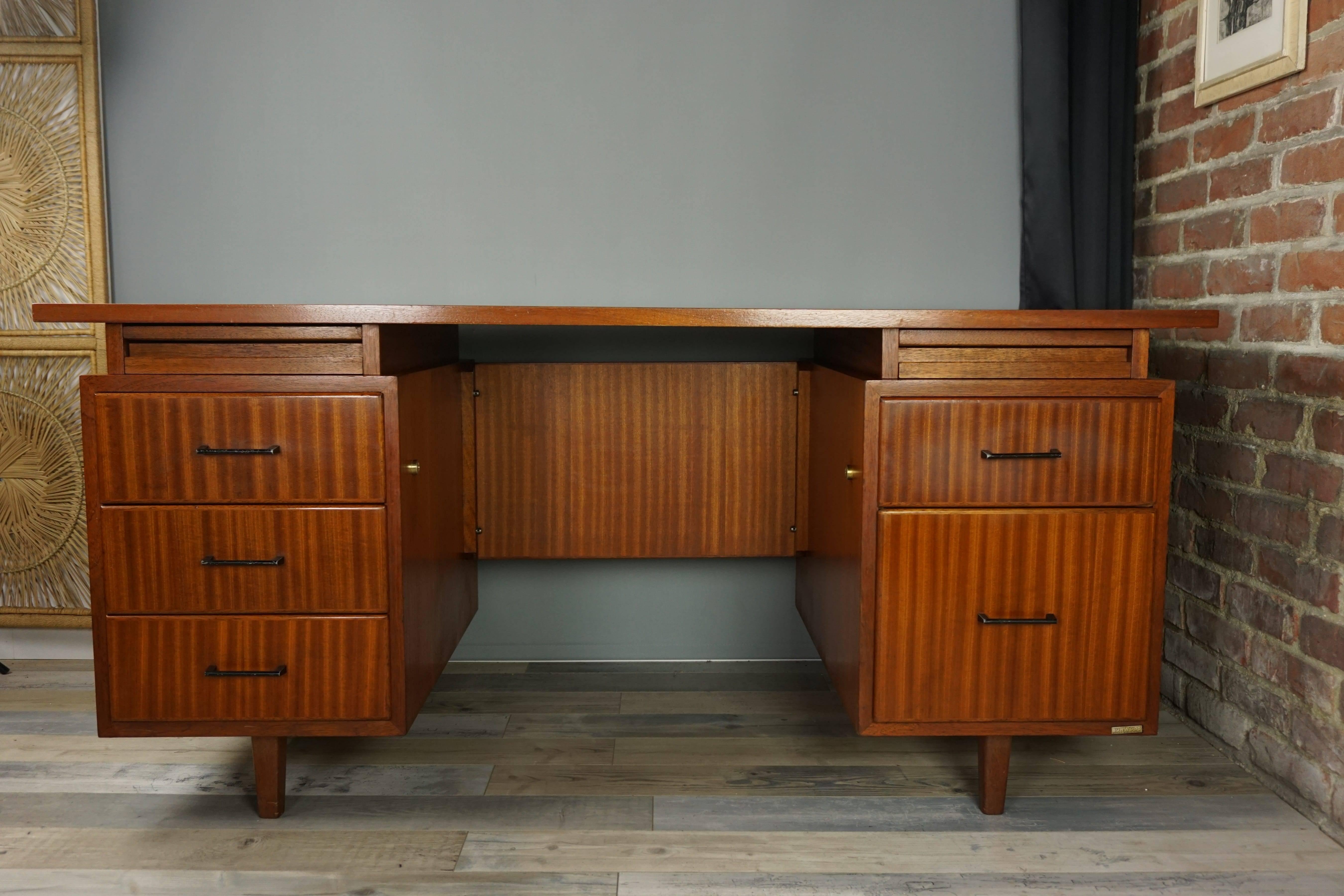 This Burwood brand executive desk, from the late 1950s, robust and high quality, consists of a rectangular tray resting on two boxes opening with five drawers mounted dovetail. One of them is a filing cabinet drawer and two drawers pencil-holder