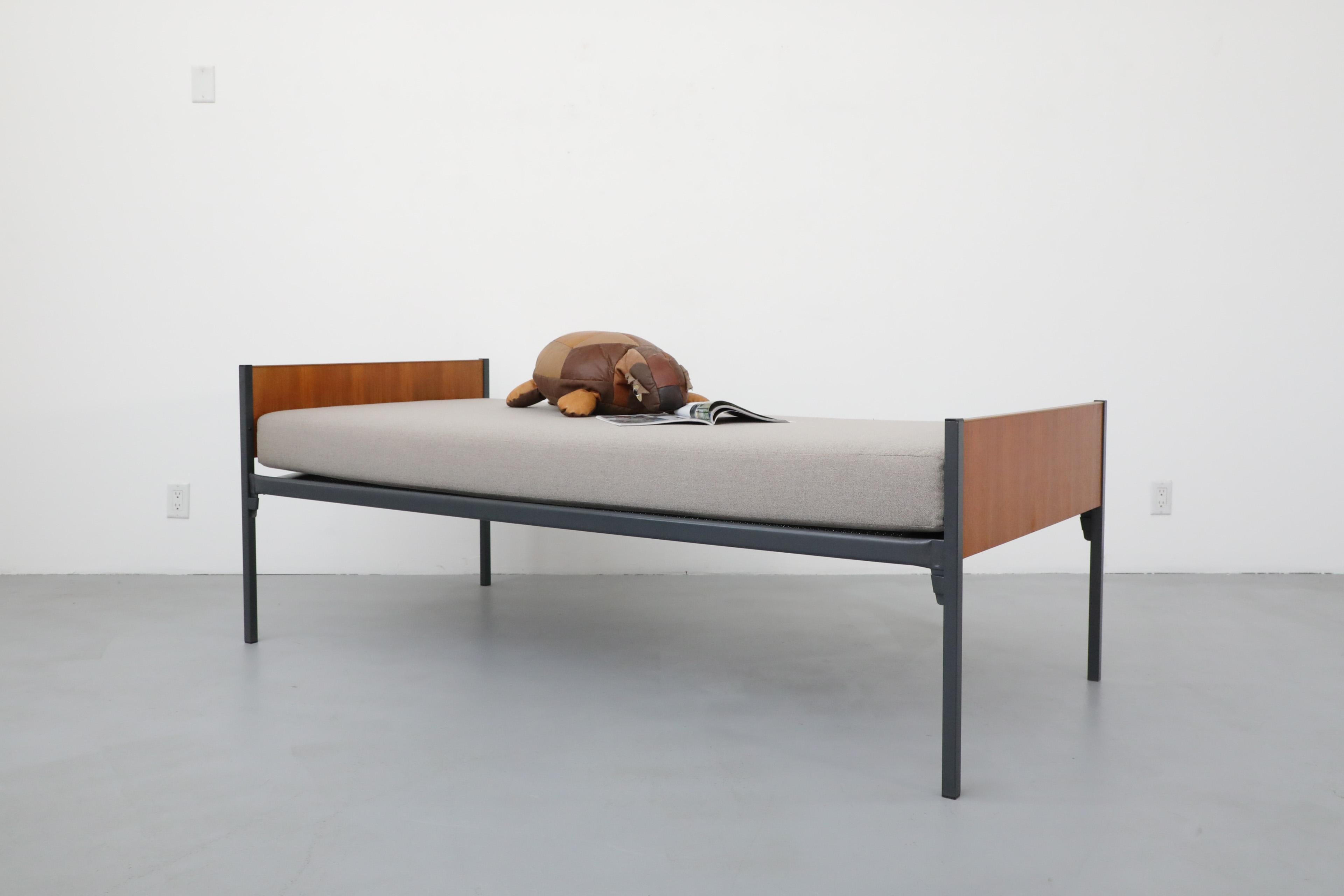 Friso Kramer inspired Dutch teak single bed or daybed with grey enameled metal frame, inset teak panels and custom dove grey mattress. The mattress frame hooks into the end panels, making moving and set up very easy. The wood has been lightly