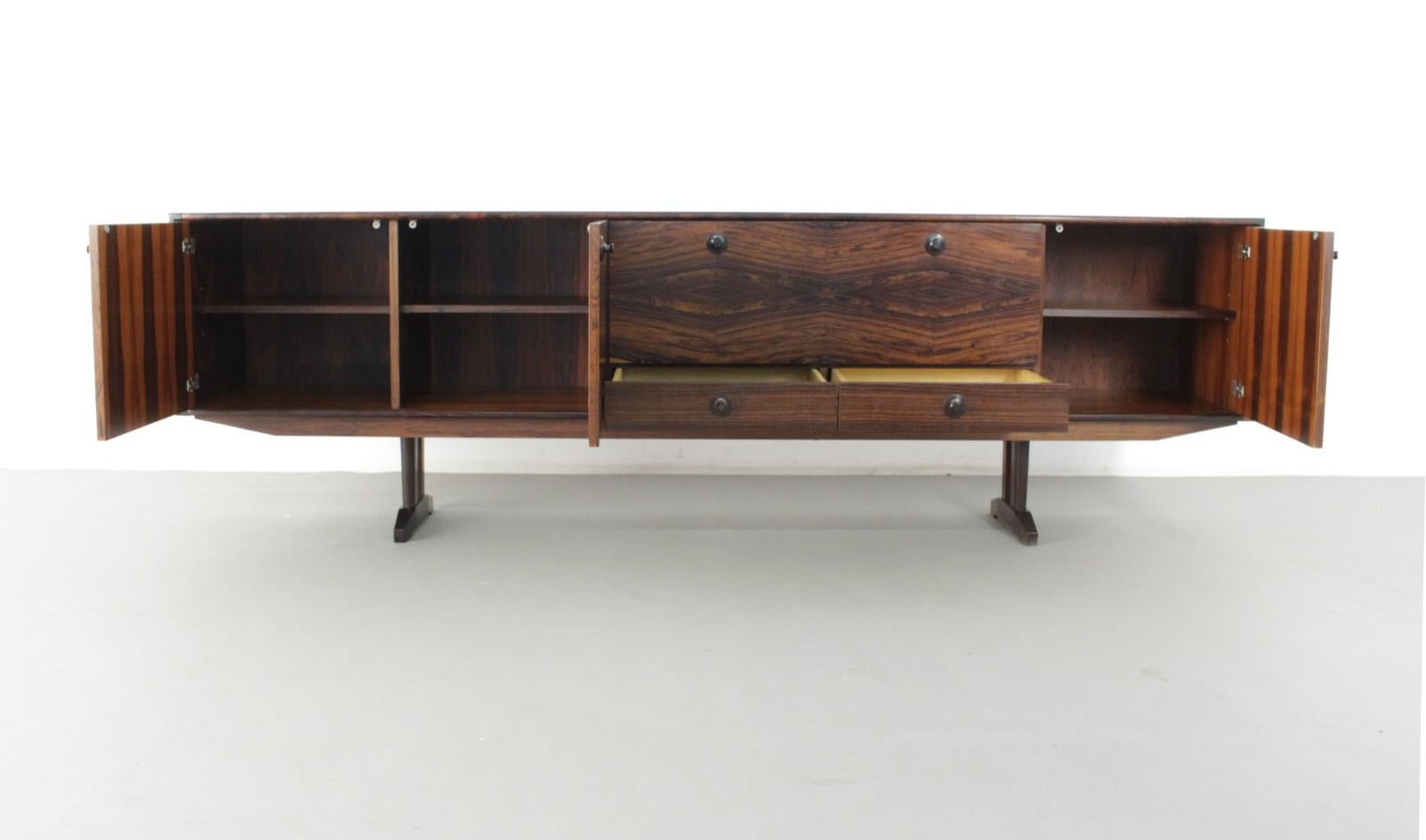 Dutch Mid-Century Modern sideboard by Fristho

Sideboard in beautiful wood veneer produced in the 1970s by Dutch company Fristho. Heavy box-shaped construction with four hinged doors and two drawers, three units with wooden recessed racks, one unit