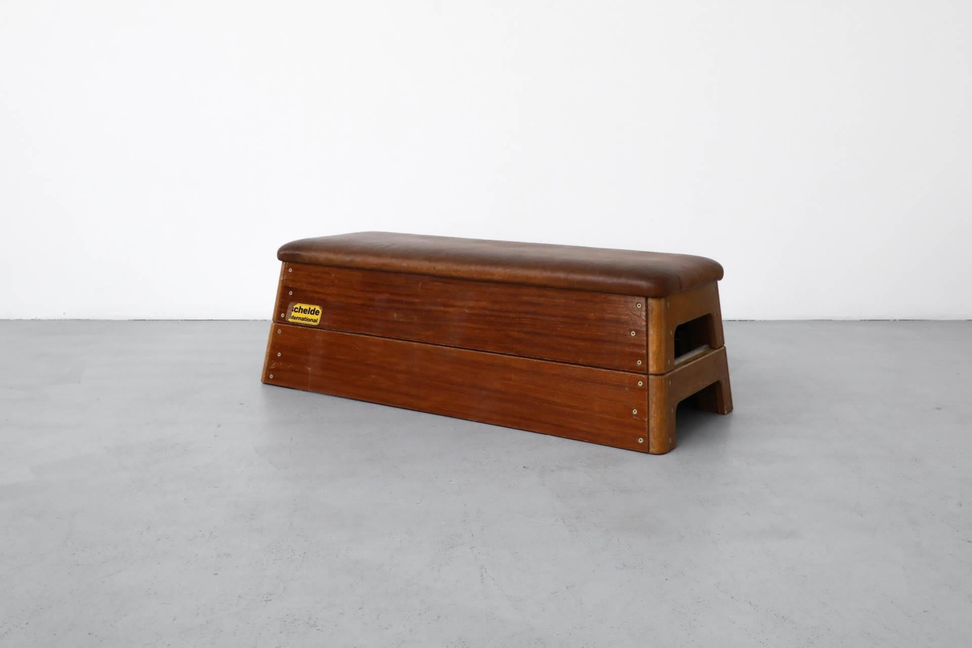 Panca da ginnastica olandese di metà secolo, multiuso. Gli strati di quercia e teak impilati ne fanno un'unità multifunzionale che può essere utilizzata come pouf, panca o tavolino.  Il pezzo conserva ancora la parte superiore in pelle e la