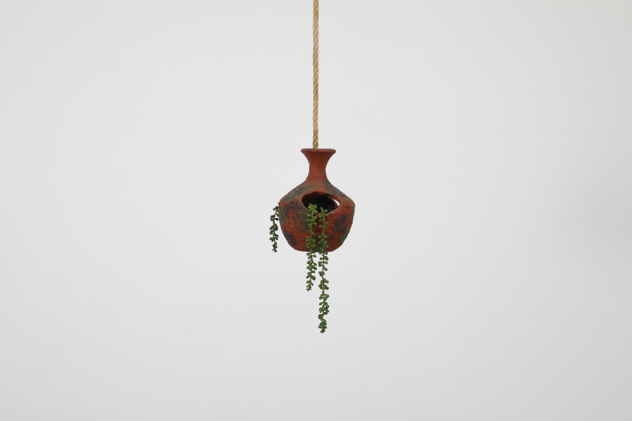 Vintage 1970's, hanging ceramic planter or bird's nest with cut-outs, hand painted design and original long rope. In original condition with visible wear consistent with its age and use. Other similar ceramics are available and listed separately.