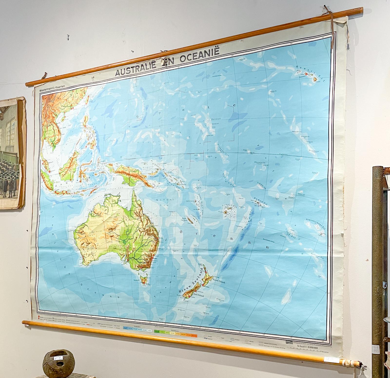 This large wall map was printed in Germany in 1961 and is mounted on linen on a simple wooden dowel frame with leather loops for hanging. The map is in full color with Australia and Oceania as the area shown. 

Mounted map measures 69