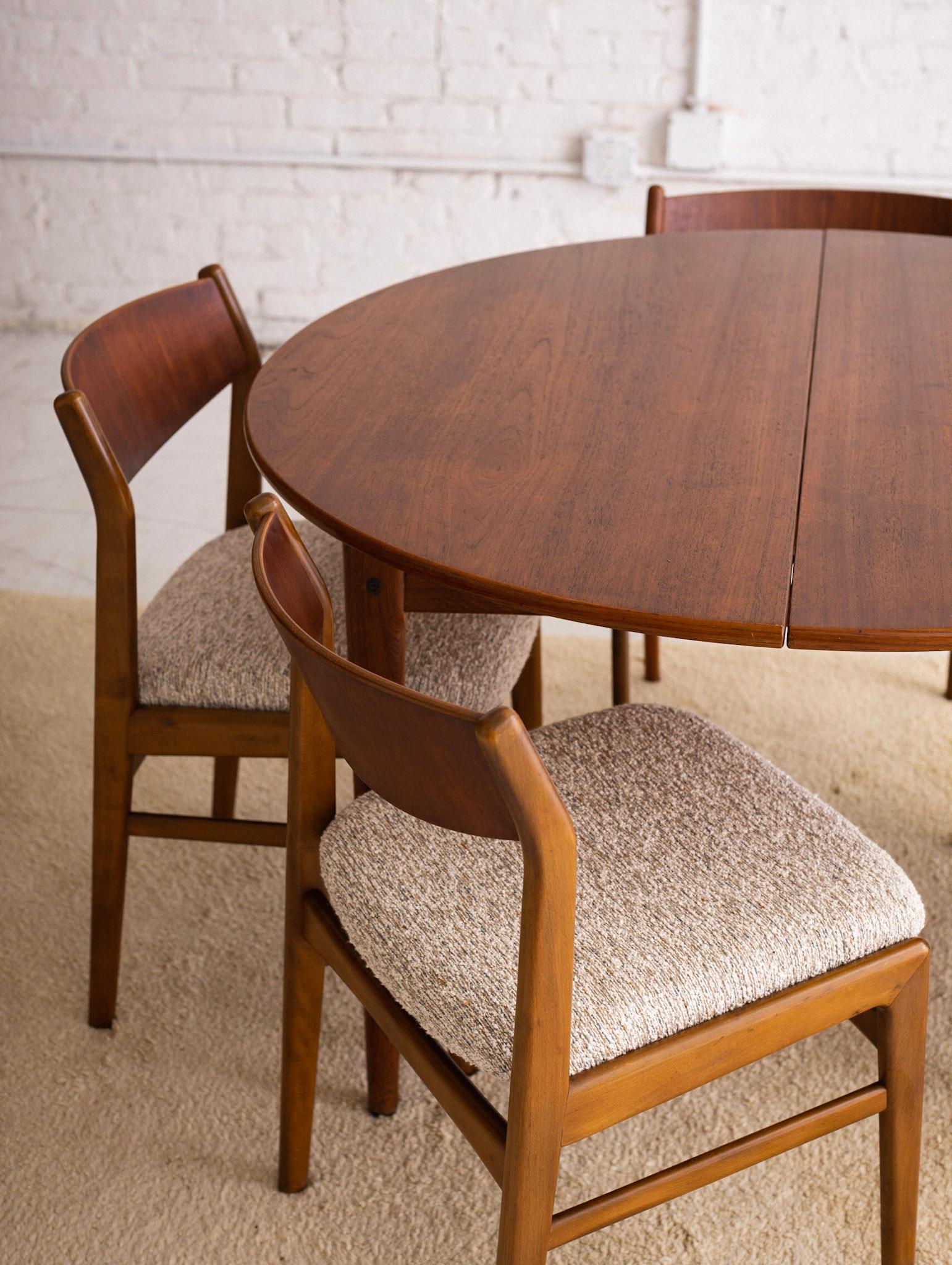 Mid-Century Modern Danish dining set with six chairs. Unrestored original finish. Chairs feature new textured beige, gray and blue upholstered seats. Comes with two leaves measuring 13.25” wide each. Table expands to a total of 75.5” wide.