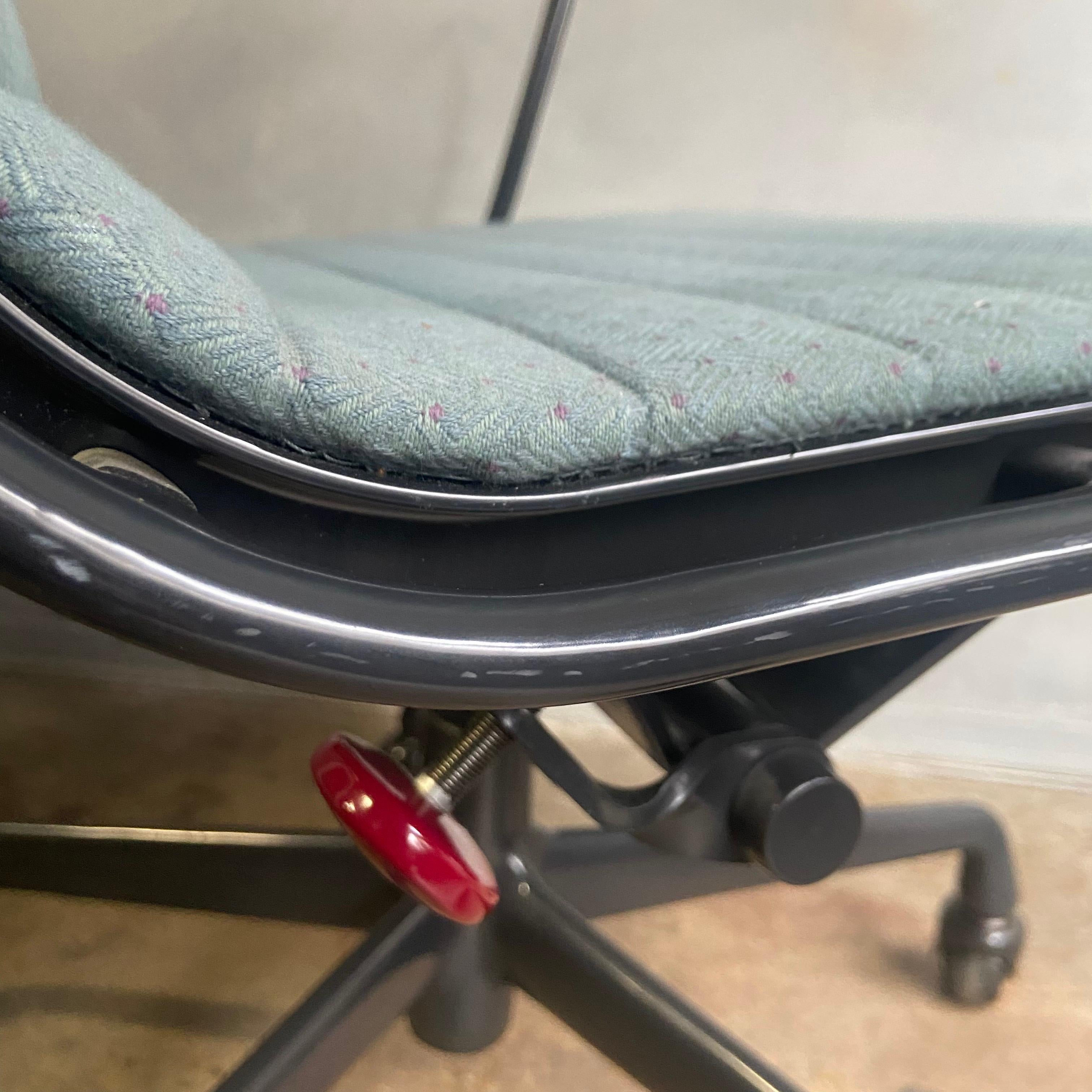 Are rare find of 1980's Aluminum group chairs from the 1980's. These chairs have a strong Memphis Milano look with period fabric and red adjustment knob that can only be found on Eames chairs for a short time. The frames are in an almost black /