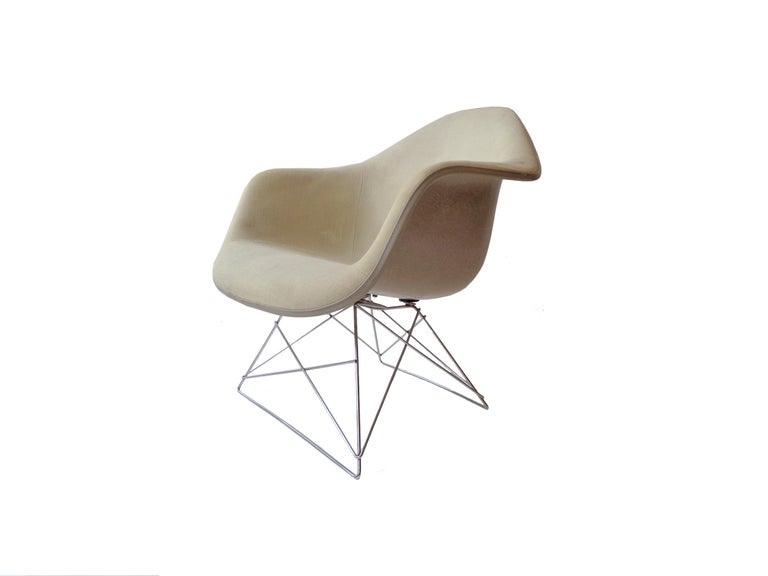 Charles and Ray Eames low armchair rod (LAR) for Herman Miller. Molded off-white fabric, fiberglass, chrome-plated steel and rubber.

Signed with manufacturer’s mark to rubber underside.