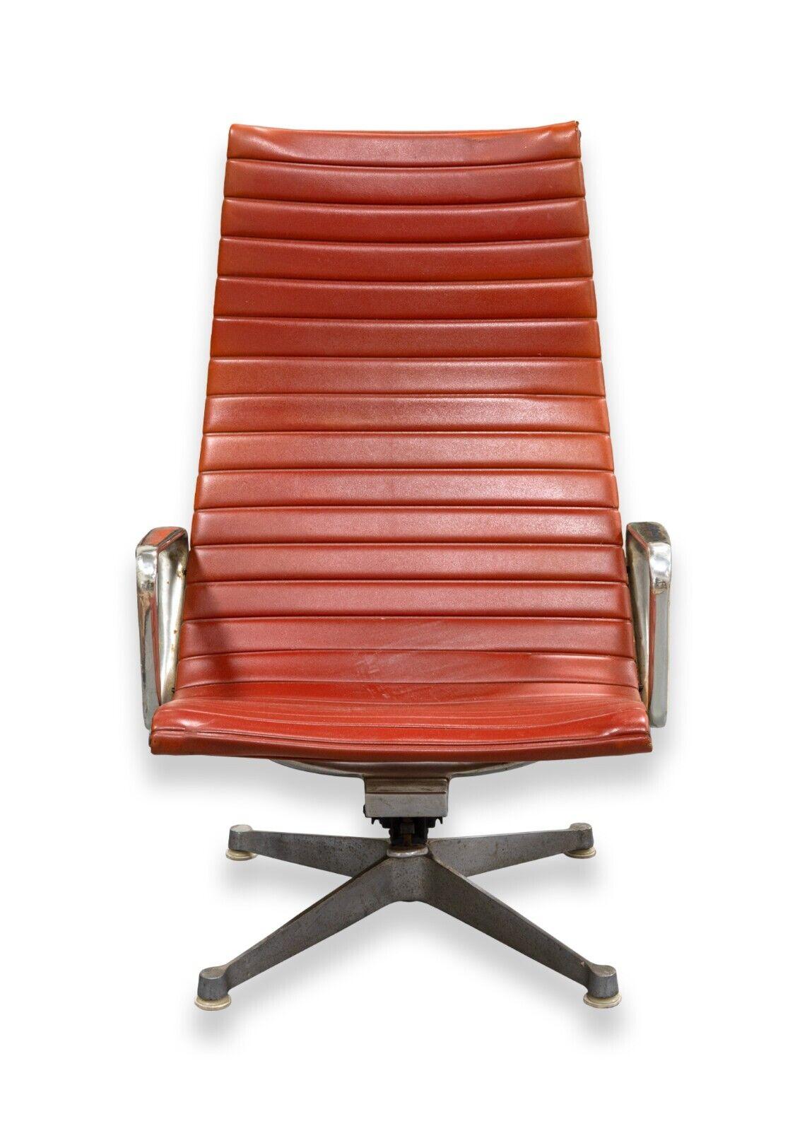 A mid century modern early Eames for Herman Miller aluminum group swivel office chair. A lovely red Eames office chair for Herman Miller. This chair features an iconic early Eames design. This chair features an adjustable seat, arm rests, four