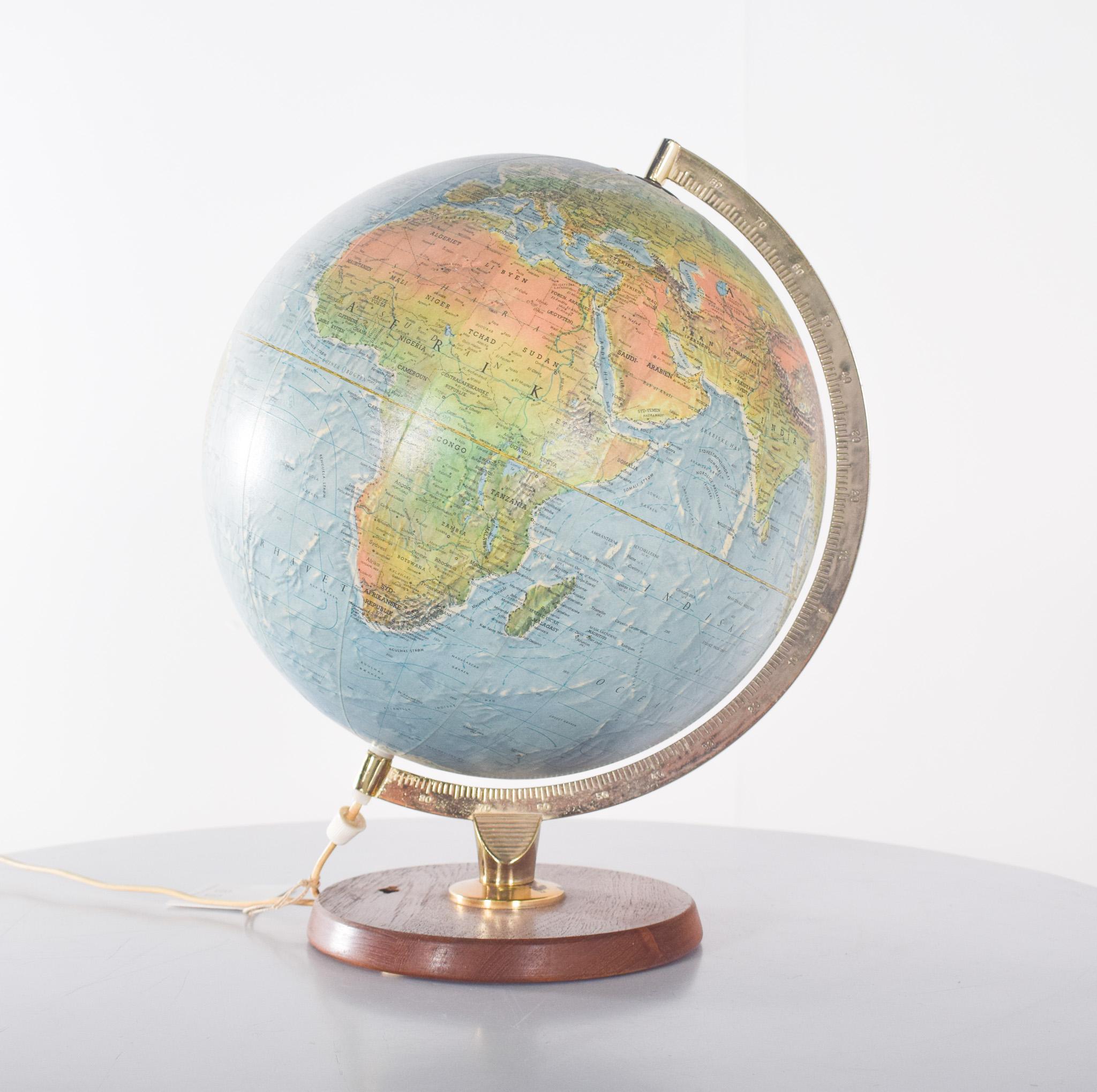 Earth globe, electrified. With polished wooden base and golden metal structure. This model presents a physical and political representation of the world, with reliefs that highlight mountain ranges and other geographic formations. The gold metal