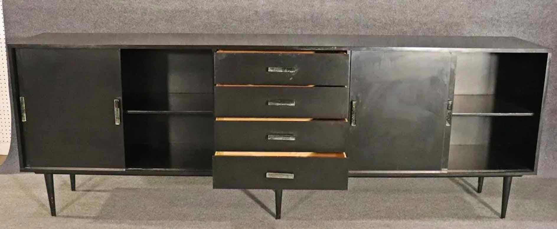 Vintage modern black sideboard with lucite hardware. Cabinet and drawer storage with tapered legs.
Please confirm location.