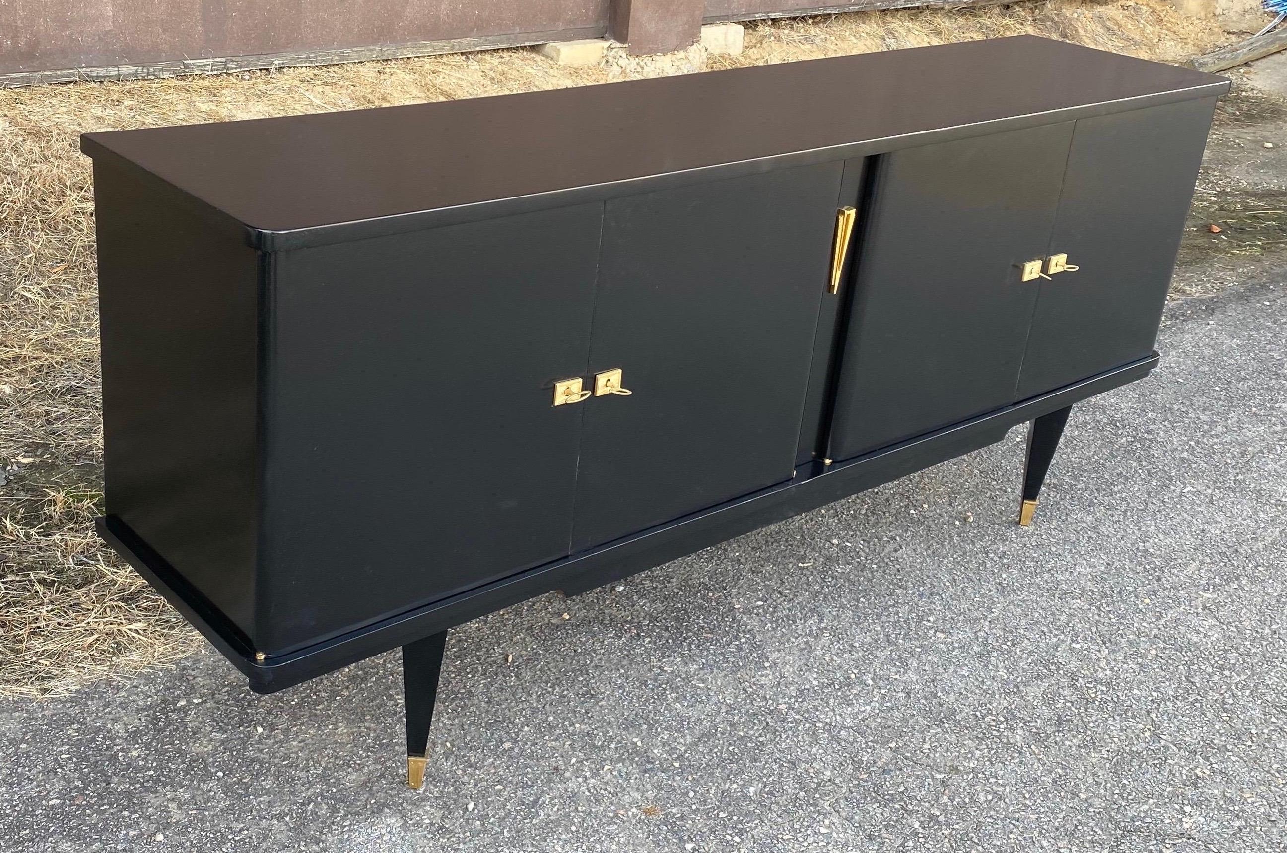 Mid-Century Modern ebonized French Art Deco credenza. Four doors open to reveal shelving, bar area and storage. Very sleek and clean lines.