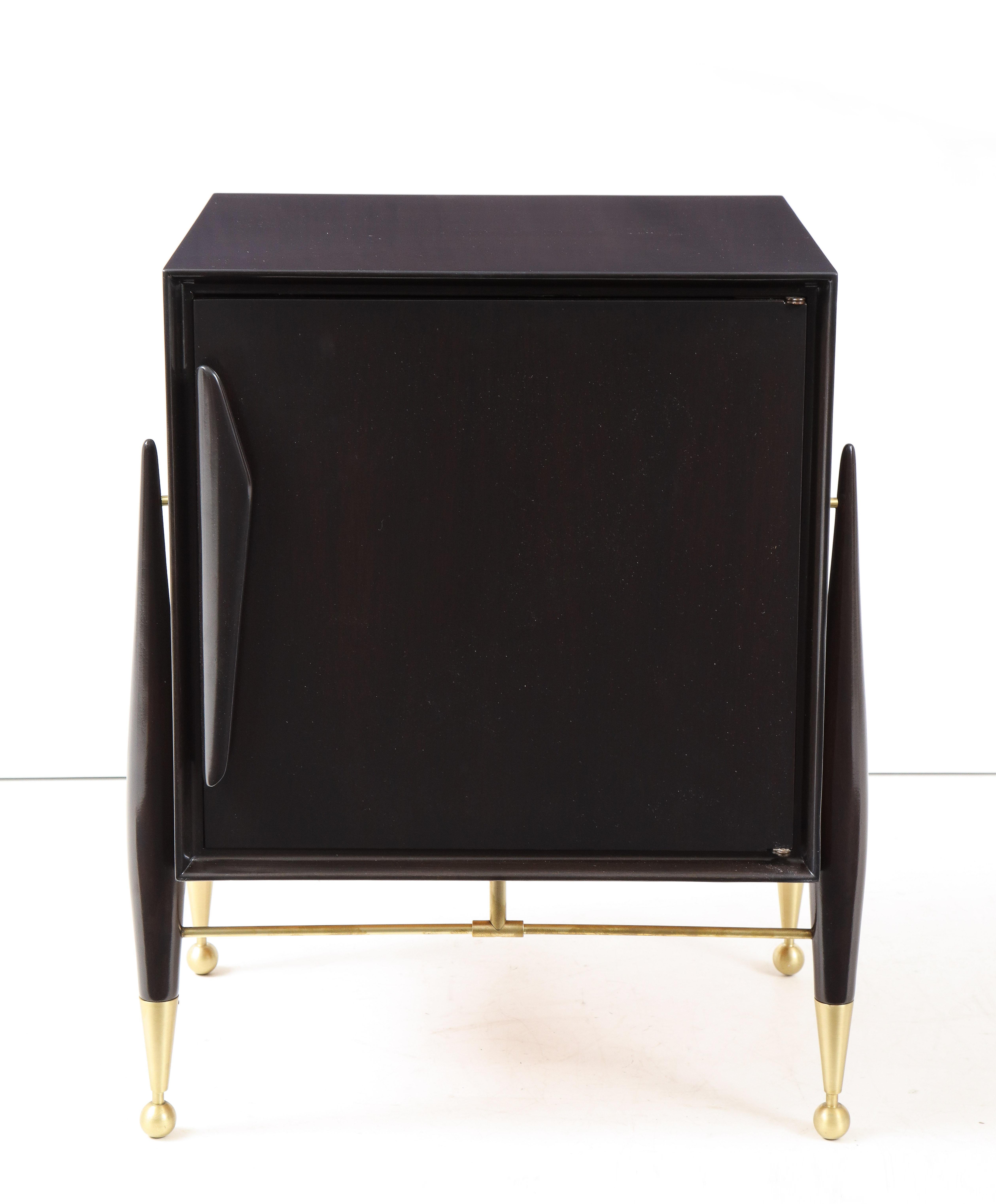 Pair of mint restored walnut nightstands in a deep brown satin finish stain and featuring brushed brass sabots and stretchers. Each houses a glass shelf.