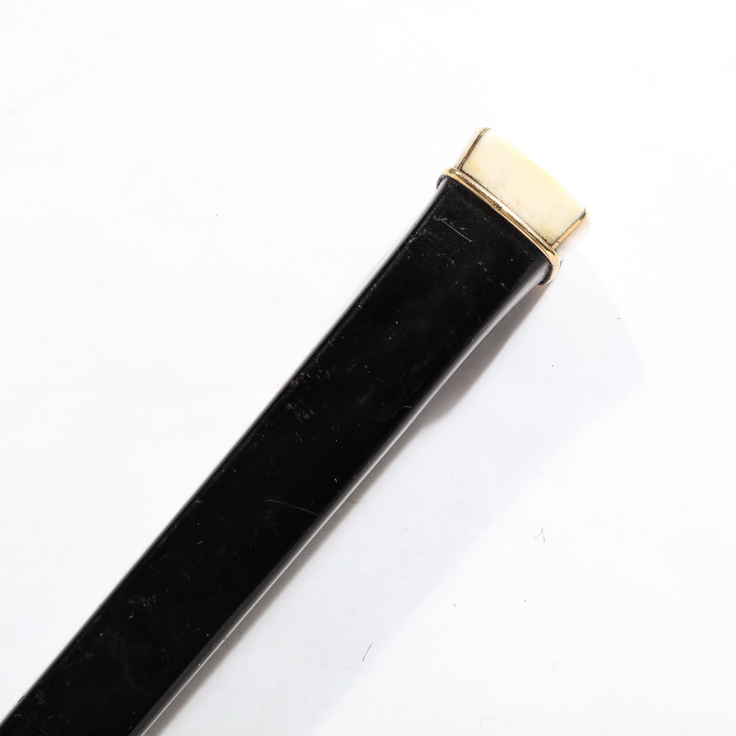 This highly sophisticated Mid-Century Modernist Walking Stick in Ebonized Walnut w/ Genuine Bone and 14K Gold Inlay Pommel Originates from Italy, Circa 1950. Features inlayed detailing in 14Karat Gold affixing the sleek bone pommel to the body of