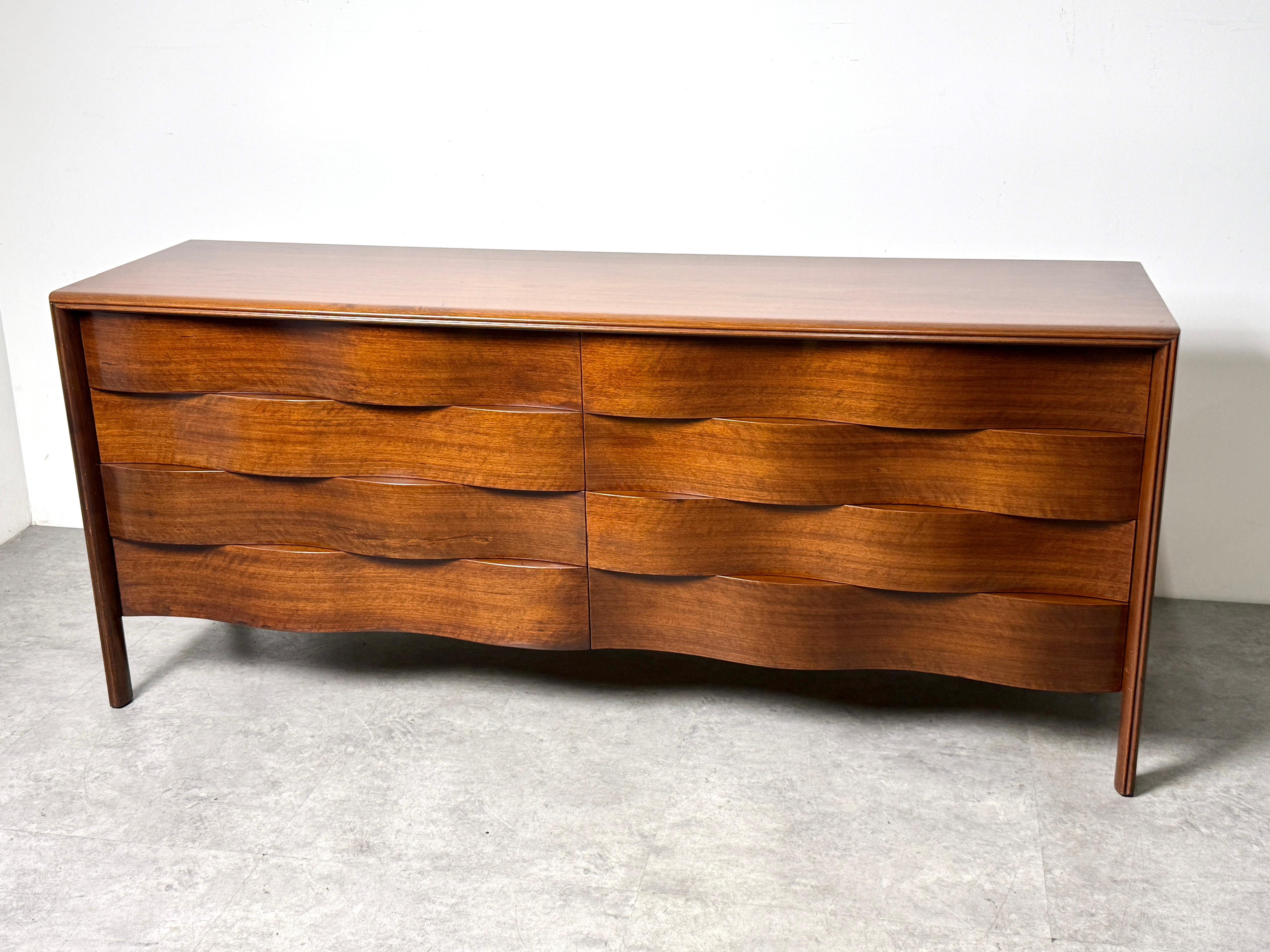 Edmond J Spence 8 drawer wave front dresser or credenza 
Circa 1950s
Manufactured in Sweden and imported by Walpole Furniture of MA

Seldom seen longer example in dark stained walnut with undulating 