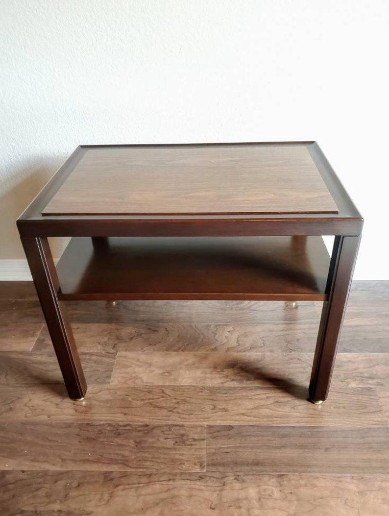 A beautiful and fine American Mid-Century custom ordered side table, model 425A, designed by Edward Wormley (American, 1907-1995) for Dunbar Furniture; Berne, Indiana. Circa 1950-1965

The two-tier table features a rich, darkly stained mahogany