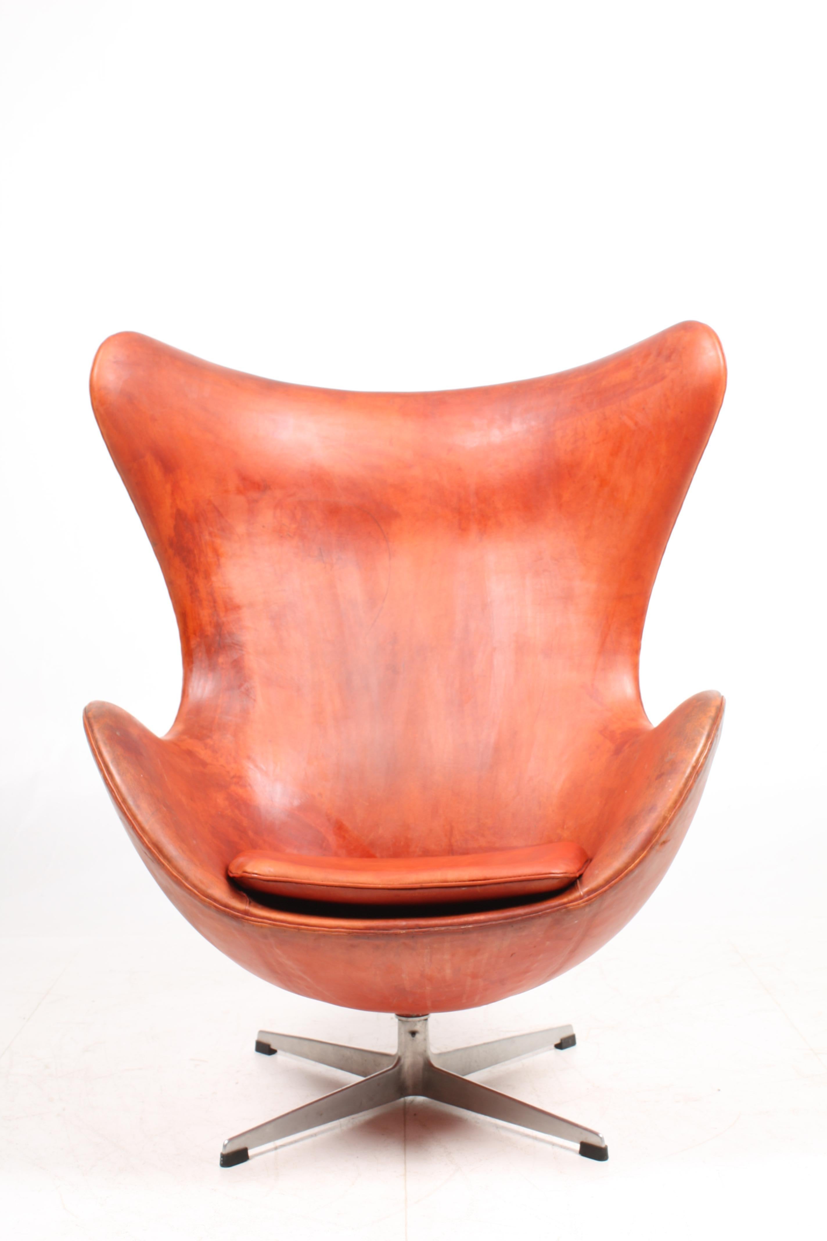 Egg chair in patinated leather designed by Maa. Arne Jacobsen in 1958. Made in Denmark, 1965. Original condition.