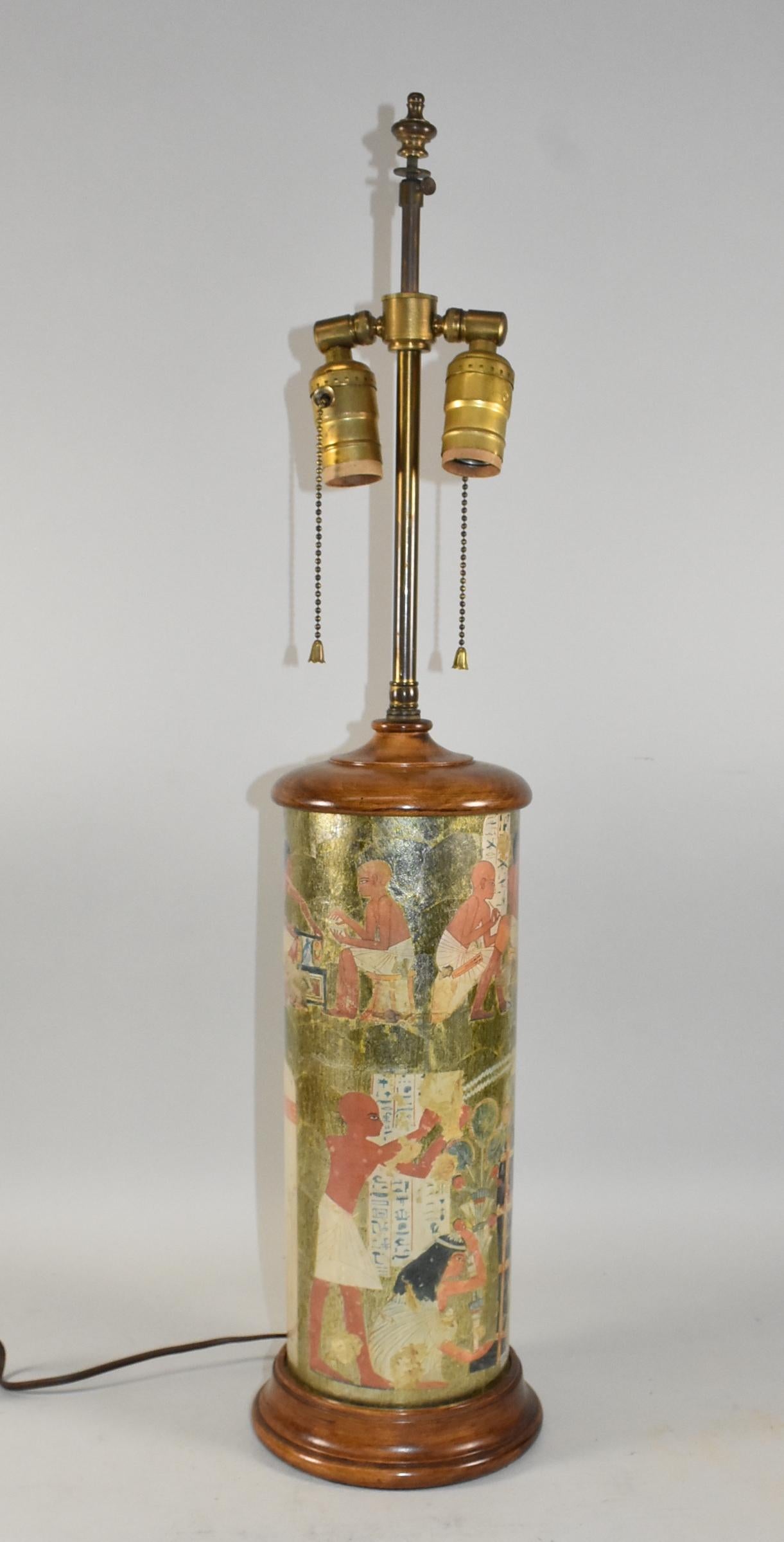 Lampe de table en verre à motif égyptien du milieu du siècle, avec des scènes égyptiennes entourant la lampe.  Fond métallique et base en bois, prises de courant Leviton avec chaînes de traction.  Abat-jour original en papier mesurant 16