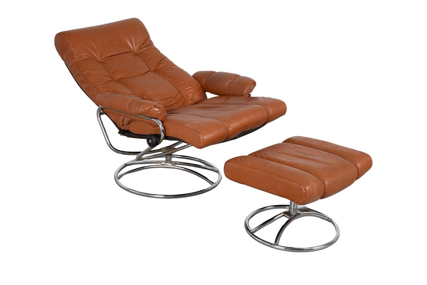 A beautiful Mid-Century Modern, stylish Ekornes Stressless reclining lounge chair and ottoman. Features rich, leather upholstery, polished chrome frame swivel base and adjustable reclining seat back. The chair has a unique glide system that follows