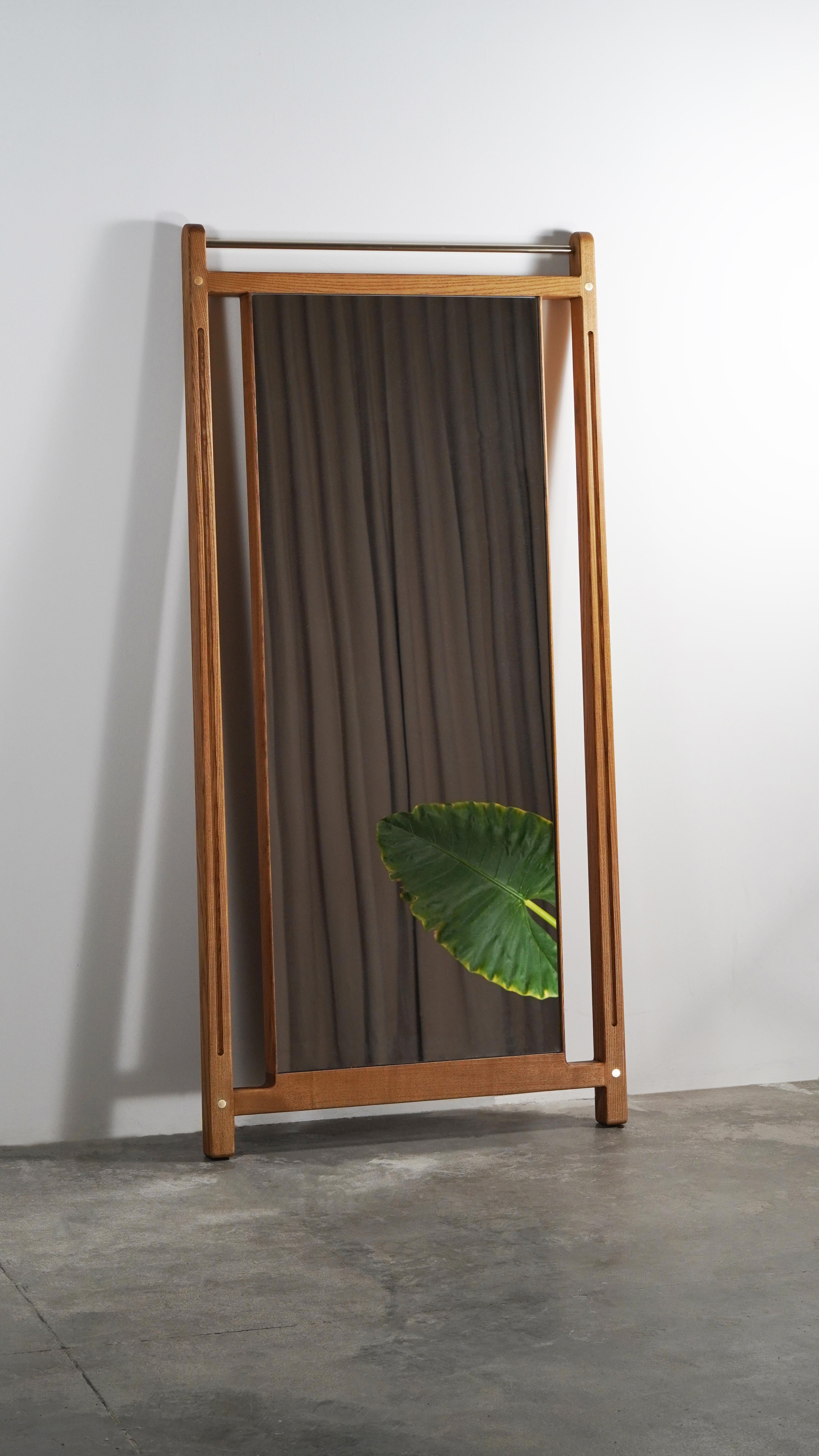 Lo splendido specchio da terra a figura intera, realizzato a mano in legno massiccio, eleva il tuo spazio con un'accattivante miscela di arte e serenità.  Il design vanta una struttura elegante che crea l'illusione di fluttuare senza sforzo sulla
