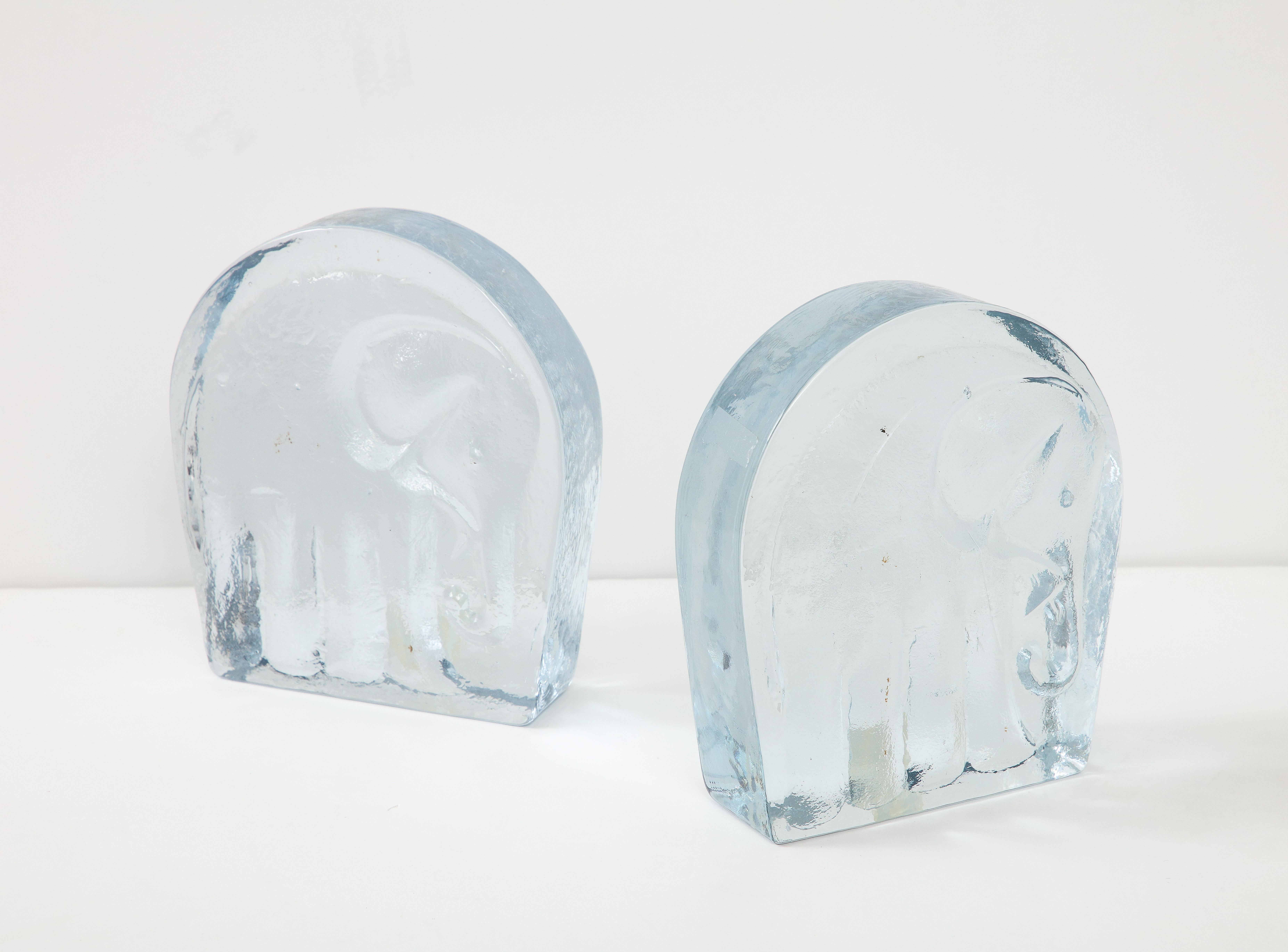 Mid Century solid cast glass stylized elephant bookends. Backs are polished smooth, while fronts are textured.
