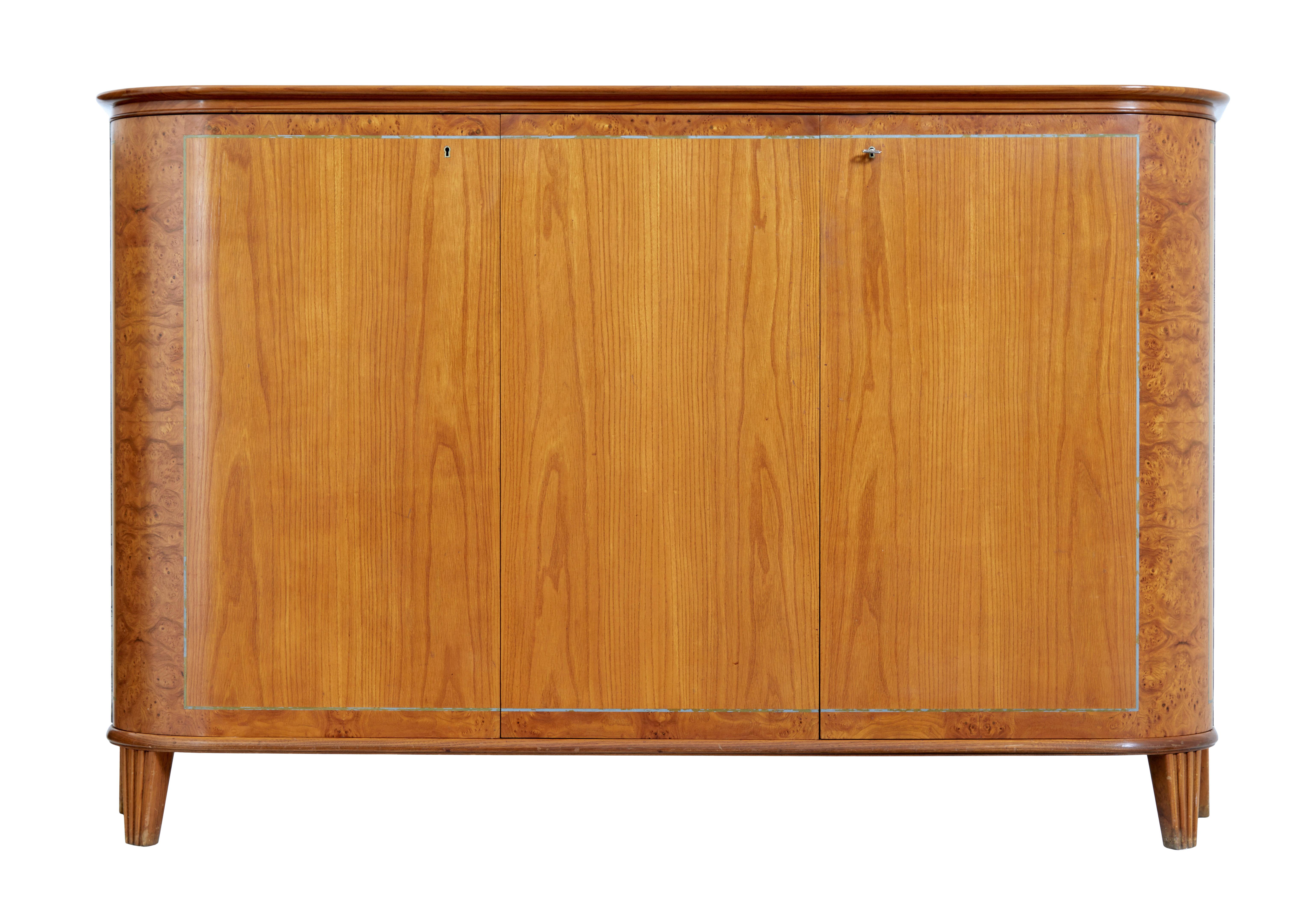 Mid century elm sideboard by thysells mobler circa 1950.

Popular model by well know maker thysells mobler, this sideboard being different from the norm being made in elm with masurian birch cross banding.

Rounded shaped top surface with