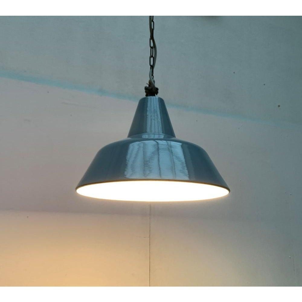 Semplice lampada a sospensione smaltata in un colore speciale.

Pendolo funzionale nella classica forma di una lampada industriale o da officina. L'ombrello è completamente in metallo e smaltato. L'ombrello blu-grigio è interrotto in nero verso il