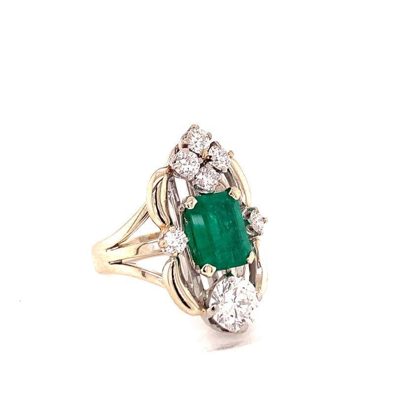 Mid-century filigree style emerald and diamond ring in 14K white gold centering one emerald cut deep, vibrant emerald weighing 2.50 ct. Also features one round brilliant cut diamond weighing 1 ct. with G-H color and VS-2 clarity as well as six round