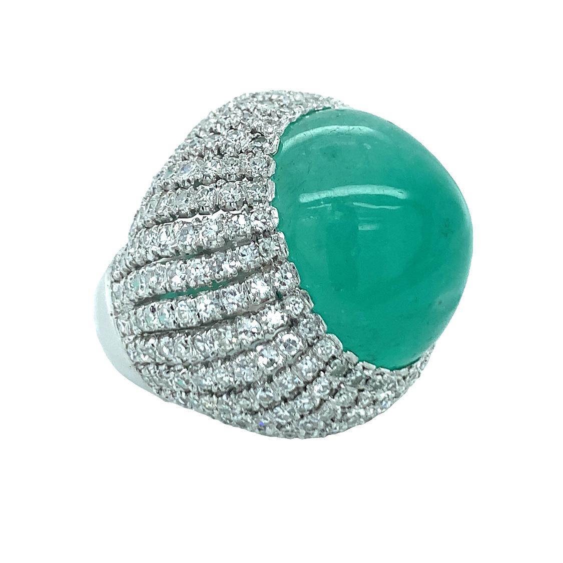Mid-century emerald and diamond 14K white gold bombe ring centering one oval cabochon, vibrant emerald weighing 30 ct. and measuring 20 x 18 millimeters in size. The ring is futher accented by 252 single round cut diamonds totaling 3.78 ct. with H-I
