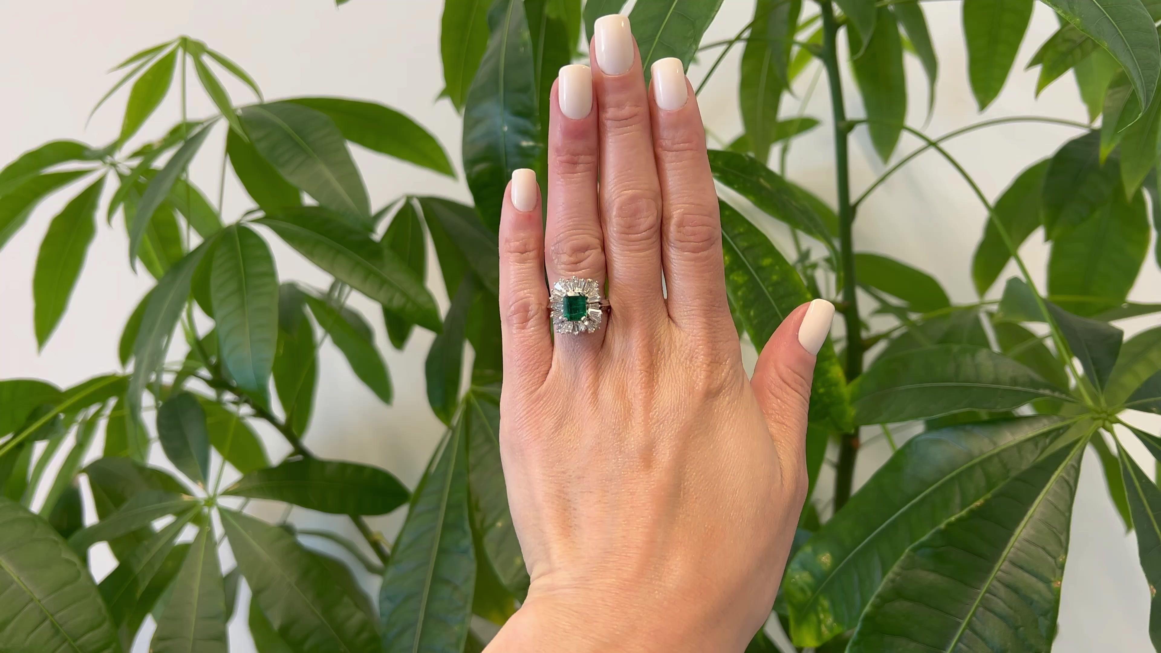 One Mid Century Emerald and Diamond Platinum Ballerina Ring. Featuring one octagonal step cut emerald cut diamond weighing approximately 1.50 carats. Accented by 24 tapered baguette cut diamonds with a total weight of approximately 1.70 carats,