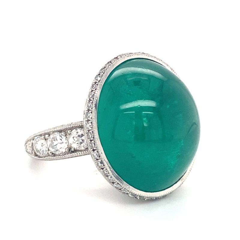 One emerald and diamond platinum ring centering one bezel set, oval cabochon deep green emerald weighing 43 ct. The ring is enhanced by single cut and old European cut diamonds totaling 2 ct. along with hand engraved accents. Circa