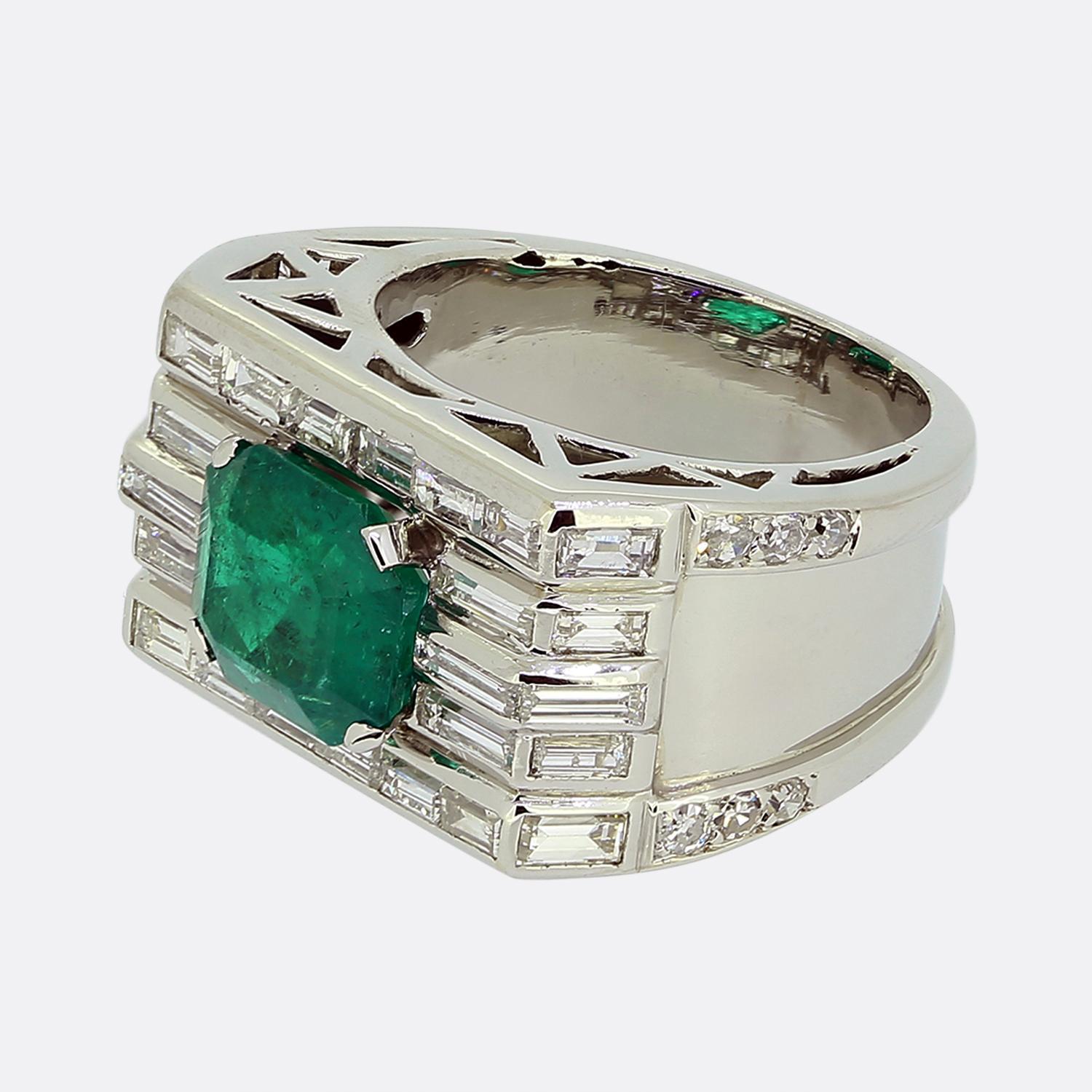 Nous avons ici une bague en platine remarquable, fabriquée au milieu du 20e siècle. Cette pièce présente une seule émeraude verte taillée en émeraude, d'une teinte riche et vibrante au centre de la face. Cette pierre principale est légèrement