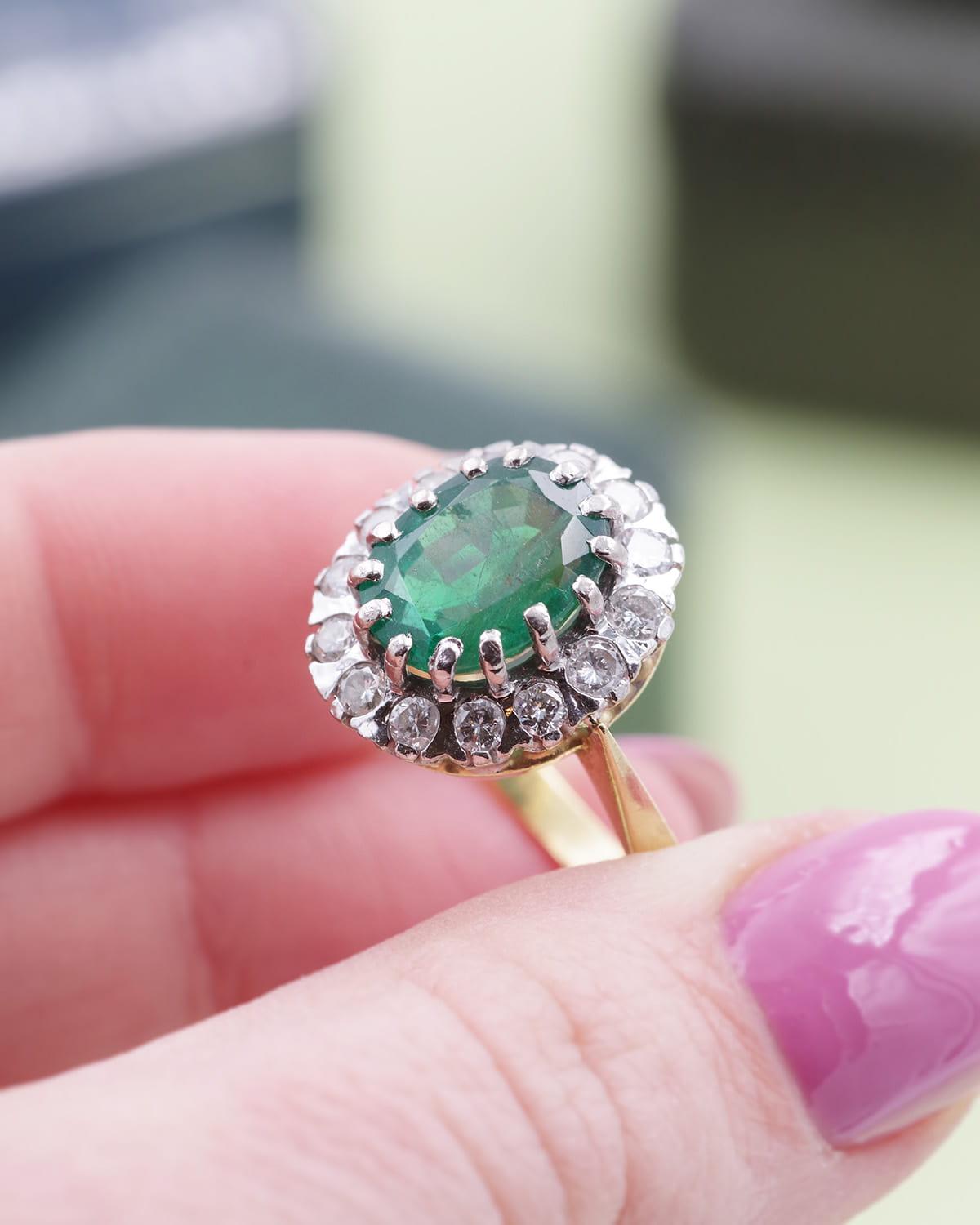 Emerald cluster ring 2.61 cts with diamonds in 18 karat yellow gold. The ring is centered with an oval-cut emerald of 2.61 carats, in a surround of 14 brilliant-cut diamonds. A certificate has been issued by the Bellerophon laboratory for the