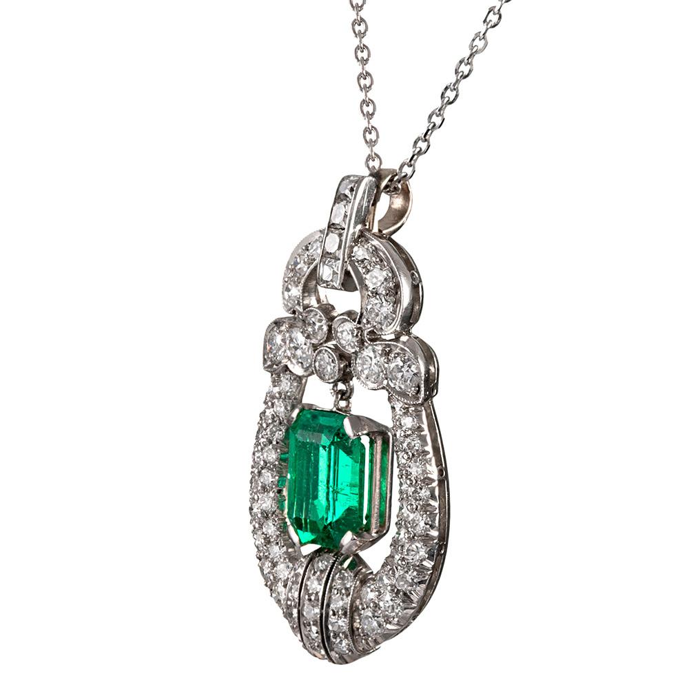 A finely made platinum pendant encircles a 1.30 carat emerald in an intricate design of brilliant white diamonds. The quality of the emerald is wonderful, with the stone exhibiting extra fine and intense color with excellent transparency. The