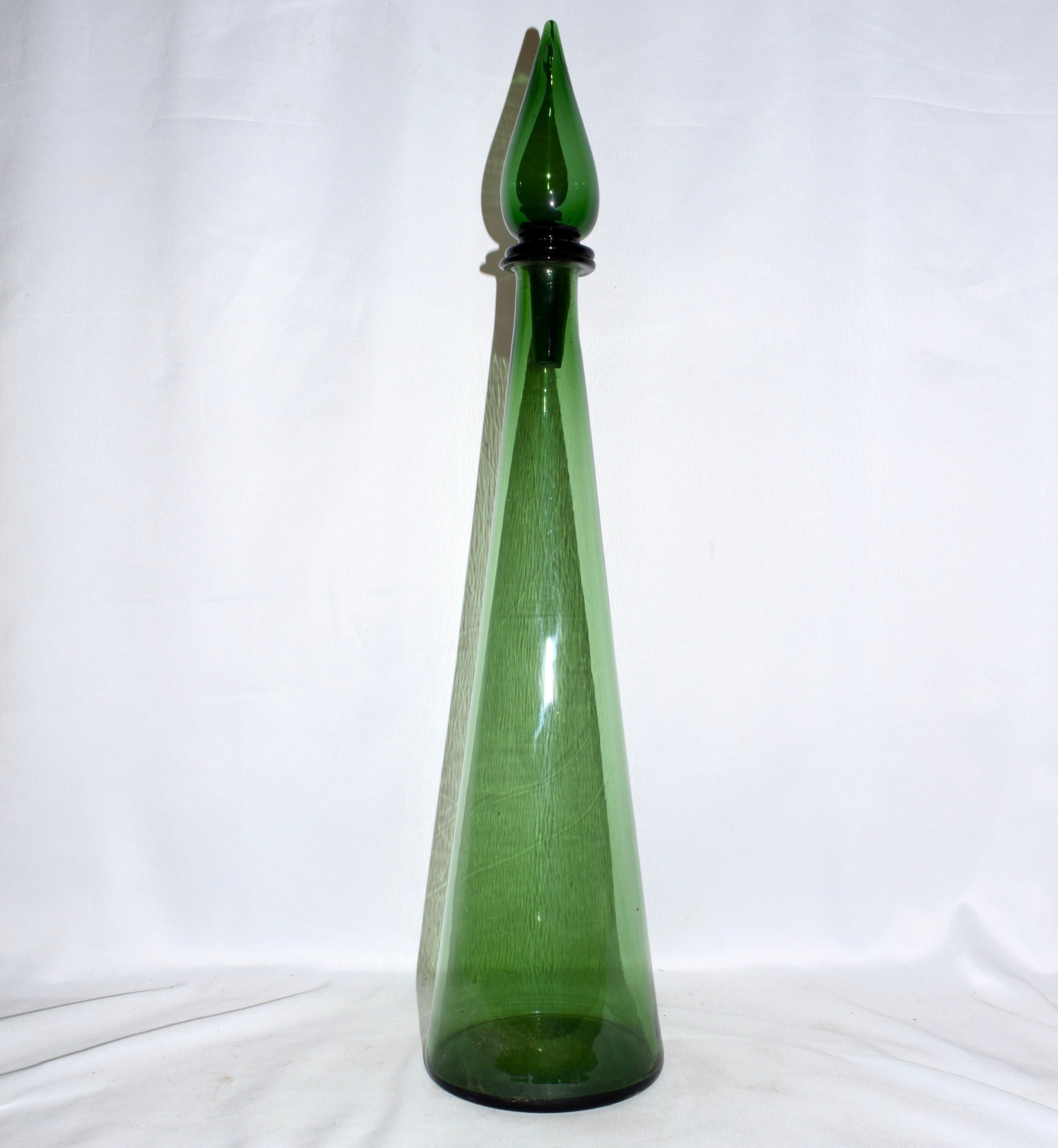 This mid-century Empoli Italian genie bottle decanter is tall and quite impressive. The green is vibrant whilst the glass is transparent which allows light to play within the bottle. It has retained its original glass stopper and it is hand blown.