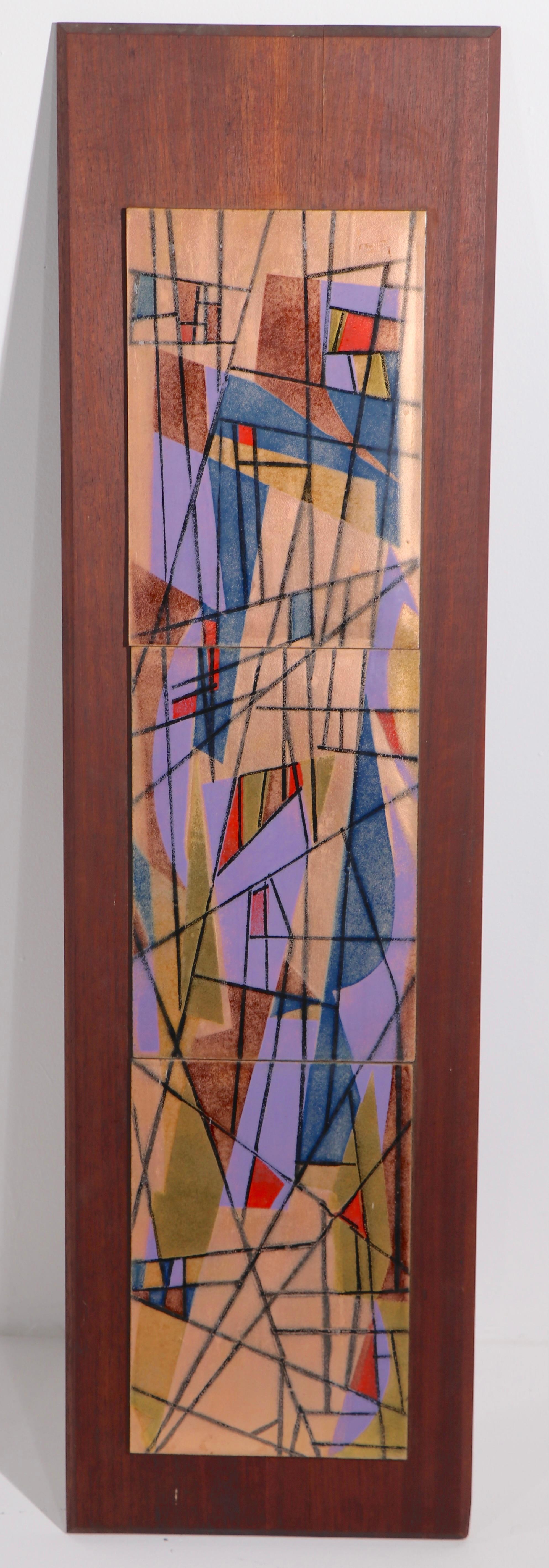 Classic modernist enamel wall hanging plaque by noted artist Judith Daner. The piece features an abstract geometric pattern executed in enamel on copper panels, which are attached to a solid wood board, that can be hung either vertically or