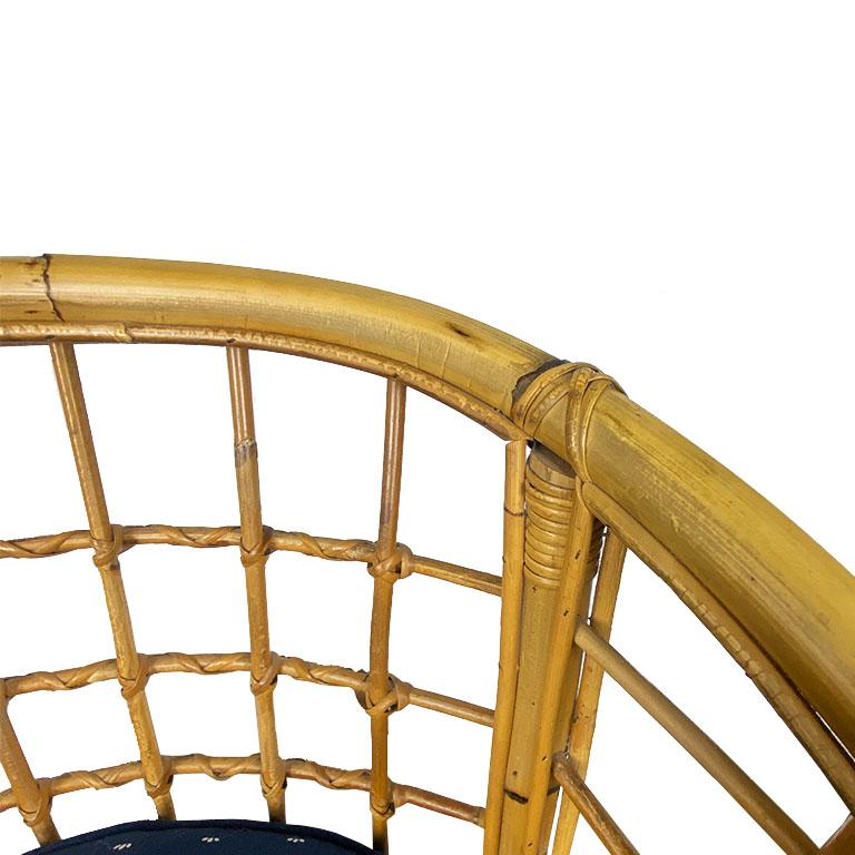 Prenez place dans ce magnifique fauteuil antique en bambou à dossier en tonneau. Cette chaise est dotée d'une assise rembourrée et d'un dossier géométrique tressé en forme de tonneau. Chacun des quatre pieds est fixé à un brancard pour plus de