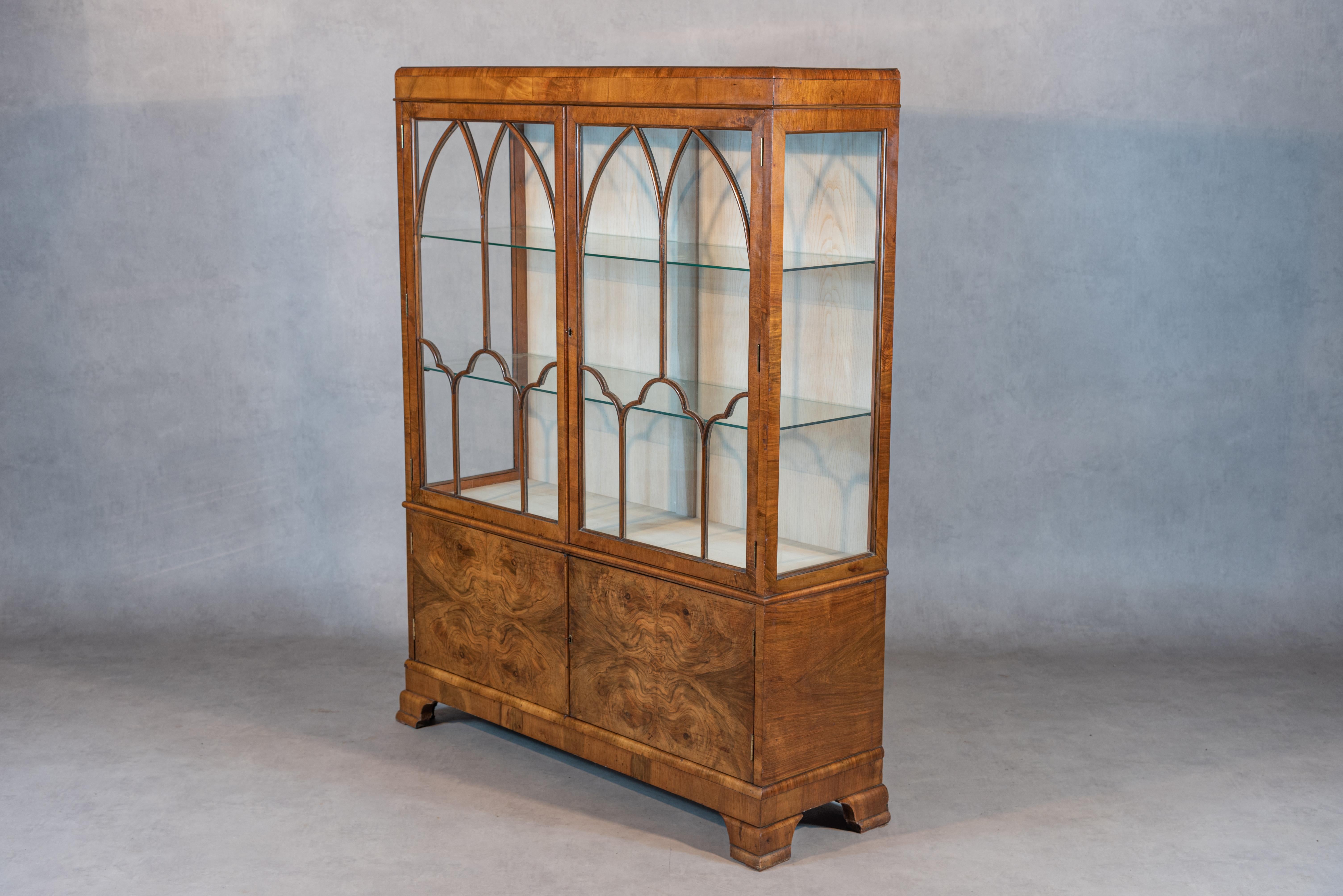 Step into a world of refined elegance with this exceptional early 20th-century English bookcase vitrine, a creation of the esteemed Waring & Gillow. Crafted with meticulous attention to detail, this piece stands as a testament to the exceptional