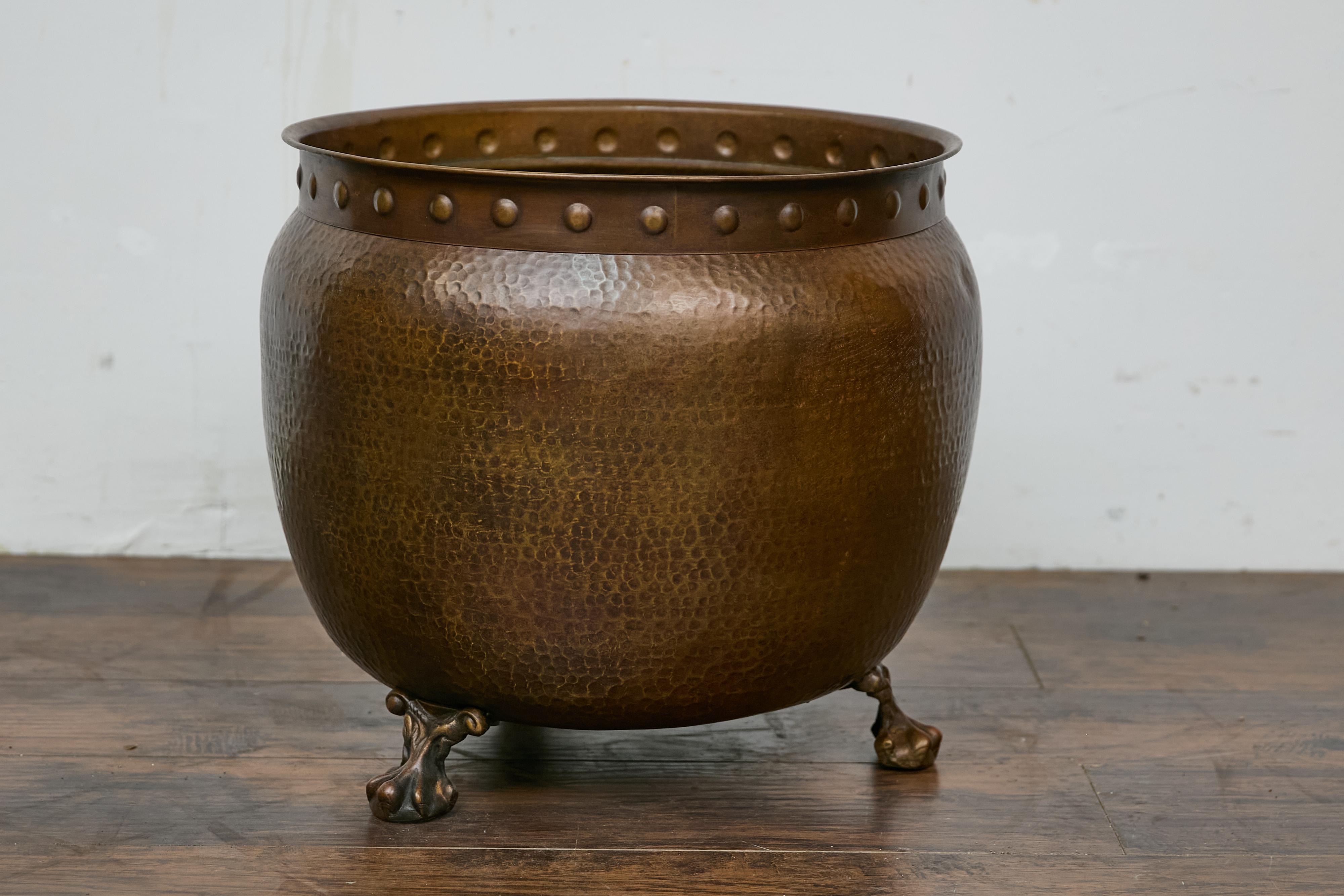 An English Arts & Crafts style copper planter. This remarkable English mid-century copper planter embodies the timeless elegance and skilled craftsmanship associated with Arts and Crafts design. Showcasing a beautifully hammered texture and accented