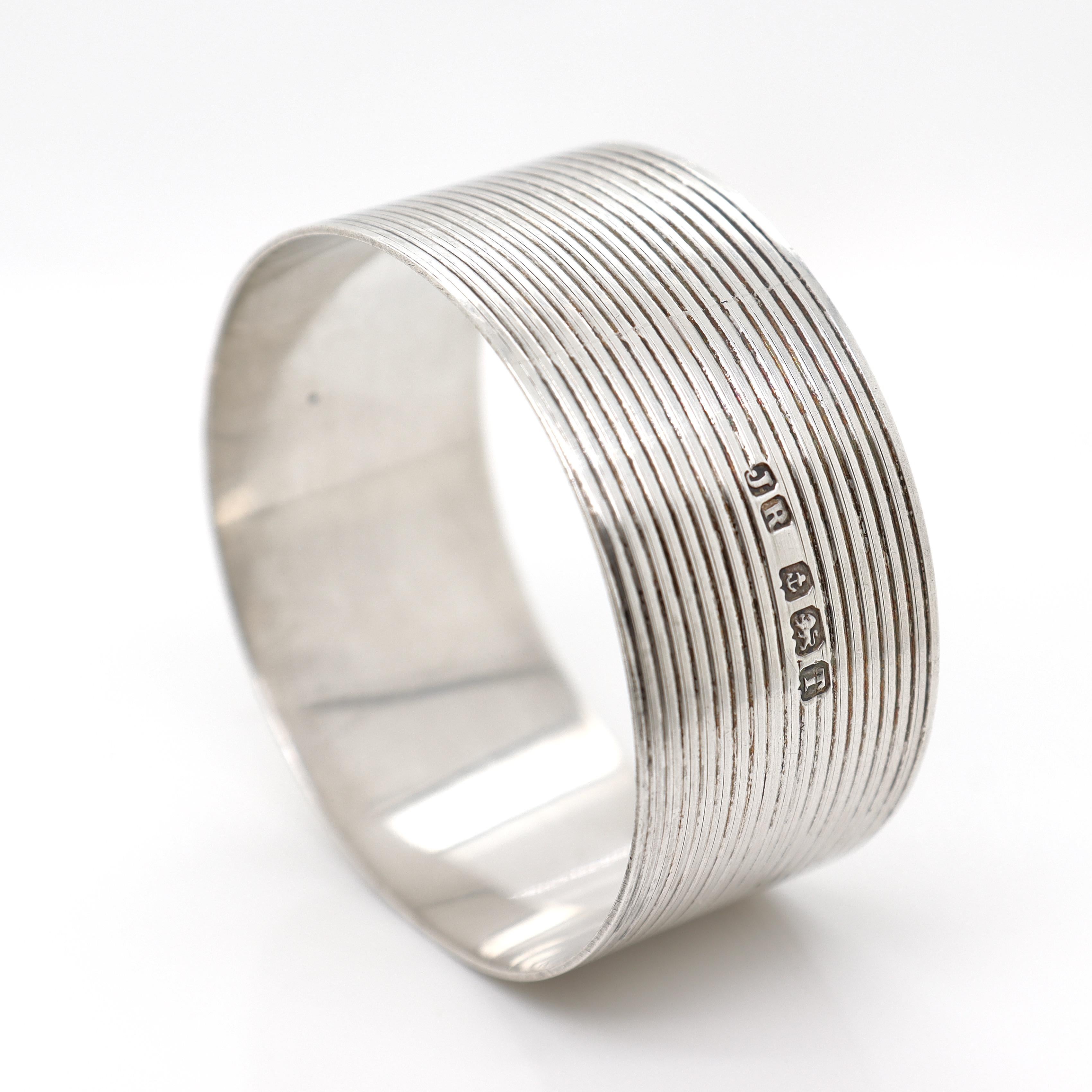 A fine Mid-Century English napkin ring.

In sterling silver.

By John Rose of Birmingham.

With engine-turned decoration around the circumference and an unengraved rectangular cartouche to the front of each.

Dating to 1943.

Simply a wonderful