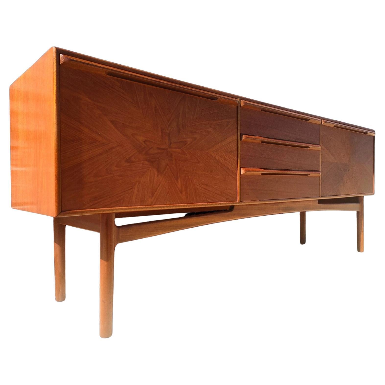 Mid Century English Modern Teak Sideboard by McIntosh
 
Above average vintage condition and structurally sound. Has some expected slight finish wear and scratching. Top has been refinished and does not have original factory finish. Very unique and