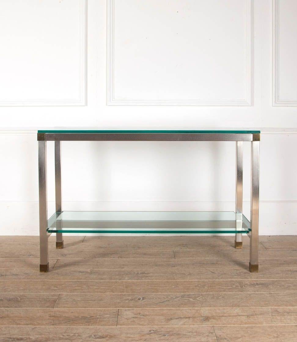 Mid-Century stainless steel console table by David Hicks. 
With a glass top and shelf below, steel frame and brass accents. 
David Hicks (1929-1998), is widely regarded as the most influential designer of his generation. His main focus was interior