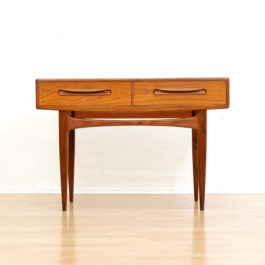 Questa consolle vintage di metà secolo è stata prodotta da G-Plan negli anni Sessanta.  Un design elegante realizzato in pregiato teak, la consolle è dotata di due cassetti con tiretti dalle forme meravigliose.