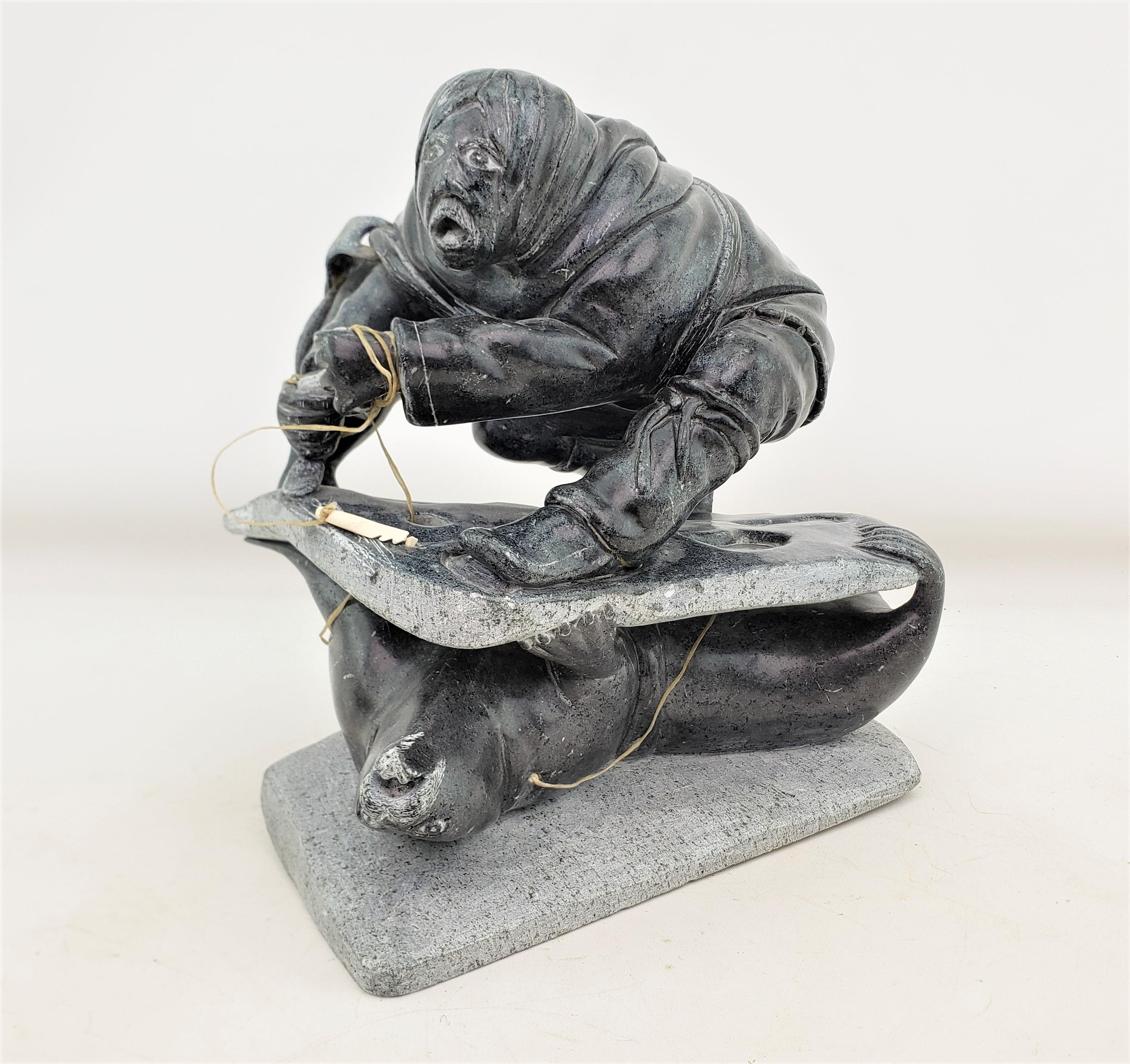 This large and well executed Inuit soapstone carving is signed by and unknown artist and dates to approximately 1977 and done in the period Inuit style. The carving is composed of soapstone with some leather accents and depicts a large Inuit man on
